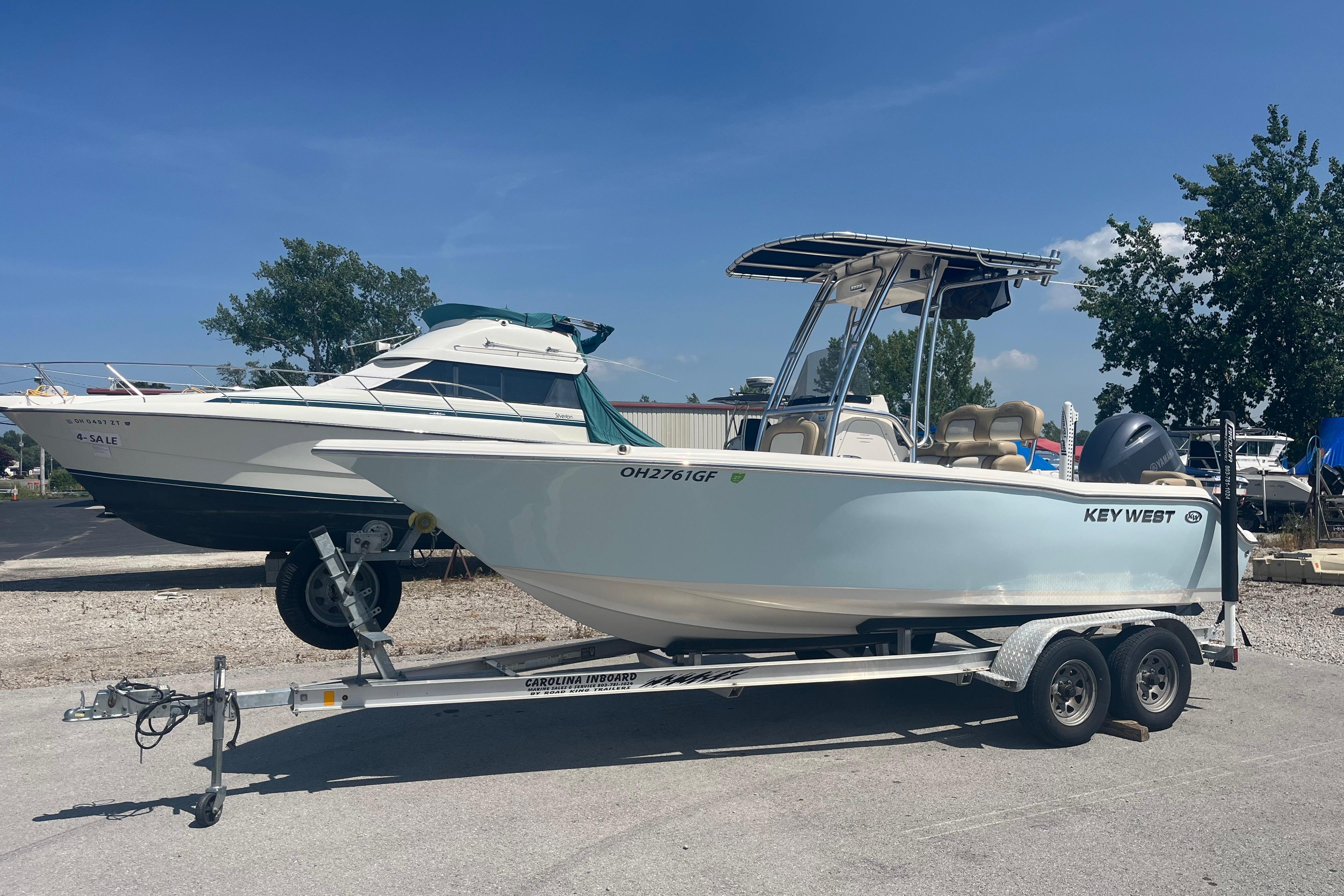 2017 Key West 203 FS boat on trailer, parked outdoors under clear blue sky.