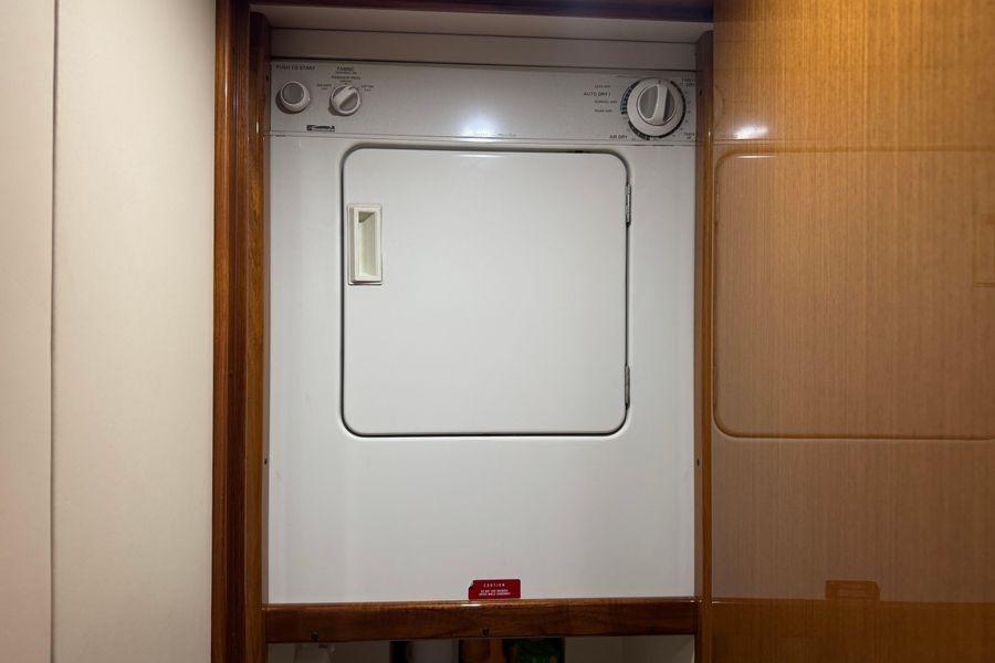 Laundry area inside 2002 Viking 61 Enclosed Bridge yacht, featuring a compact dryer.