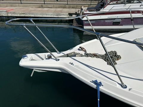 A 1997 Bayliner 2566 Ciera docked. The bow features an anchor chain.