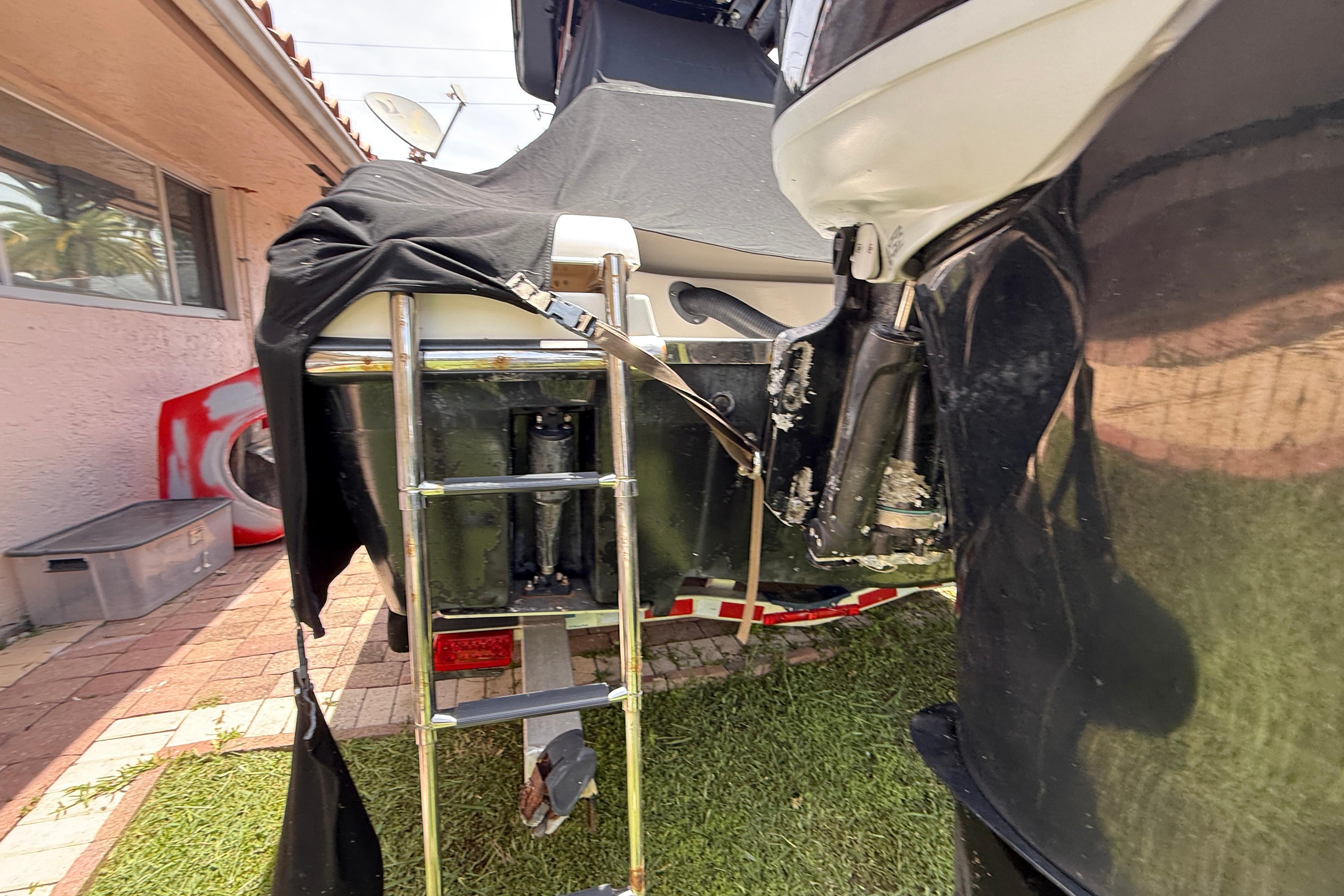 Rear view of a 2015 Blackwood 27 boat with ladder and cover.