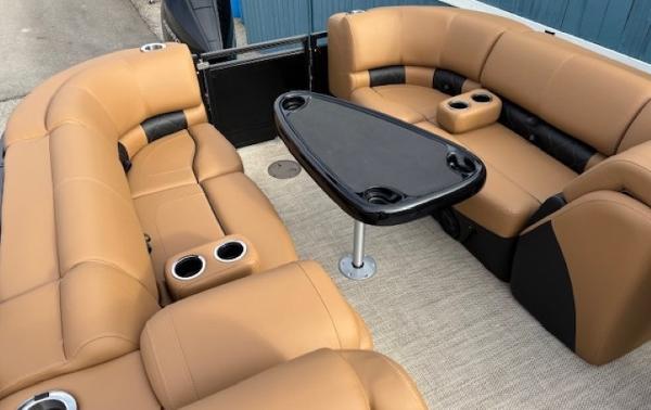 2025 Regency 230 LE3 boat interior with tan seating and black table.