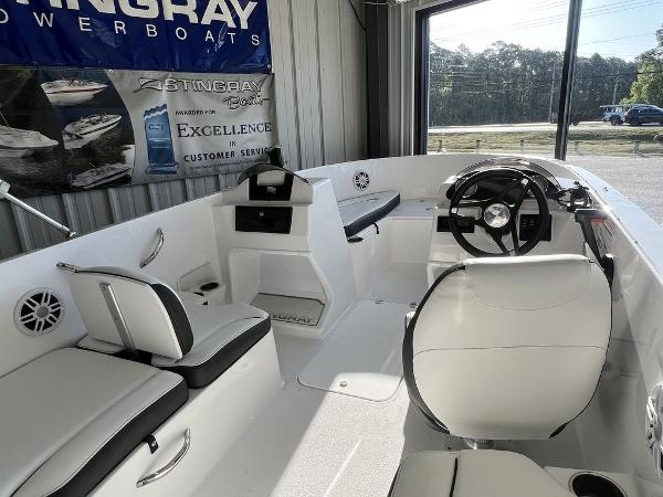 2025 Stingray 172SC boat interior with white seating and steering wheel in showroom.