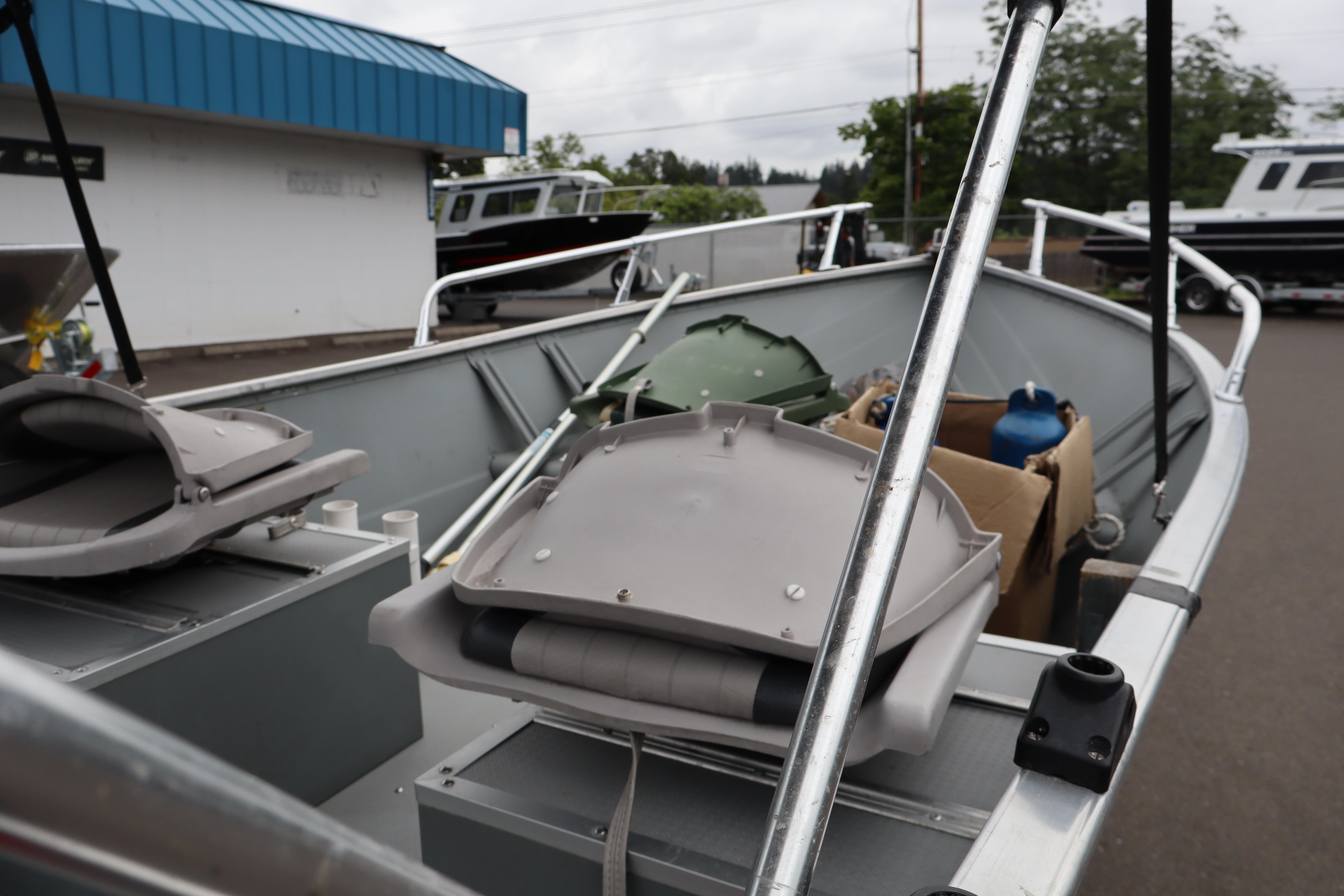 2006 Smoker Craft Alaskan 15 boat with equipment, parked outdoors.