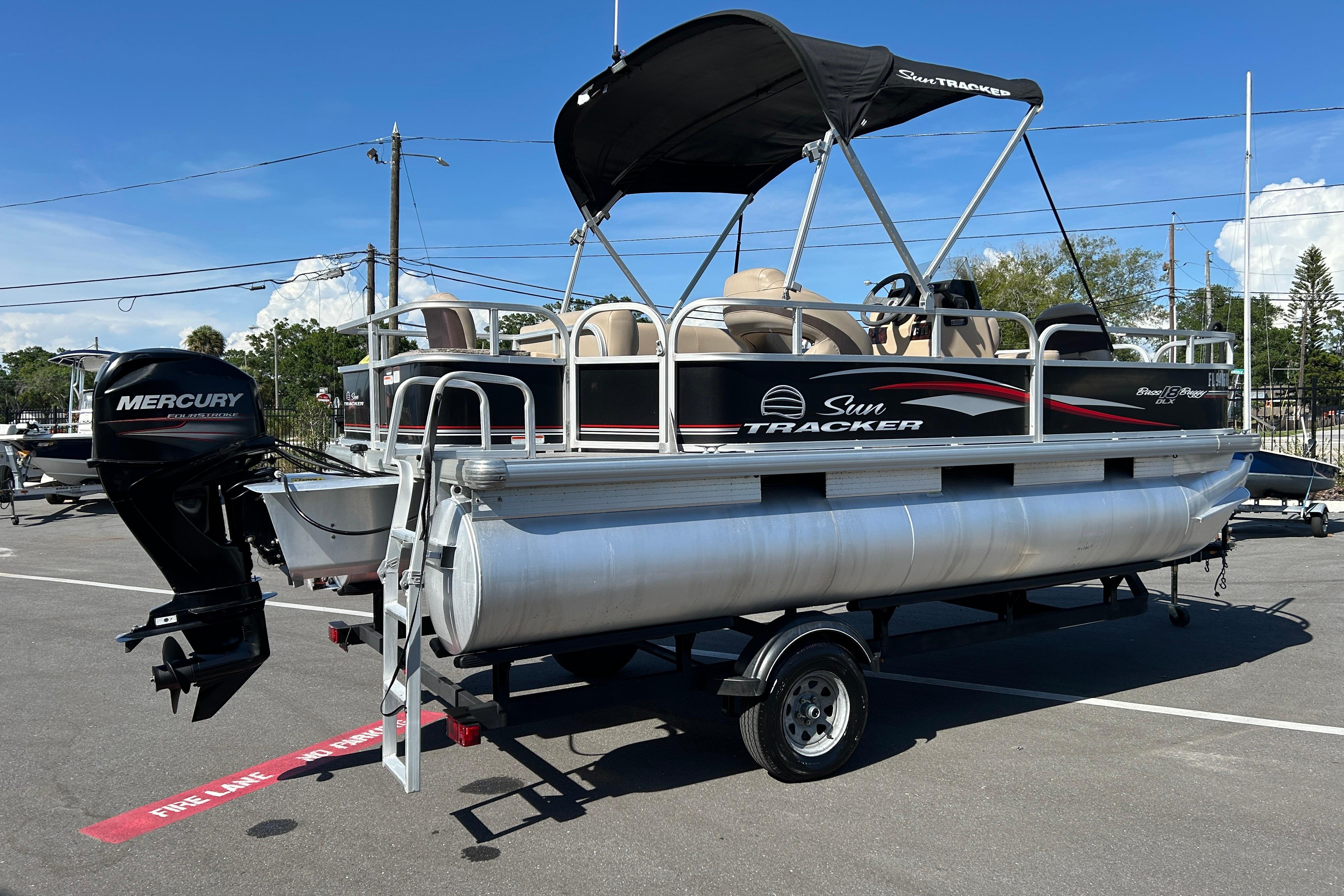 2017 Sun Tracker Bass Buggy 18 DLX pontoon boat with Mercury outboard motor on trailer.