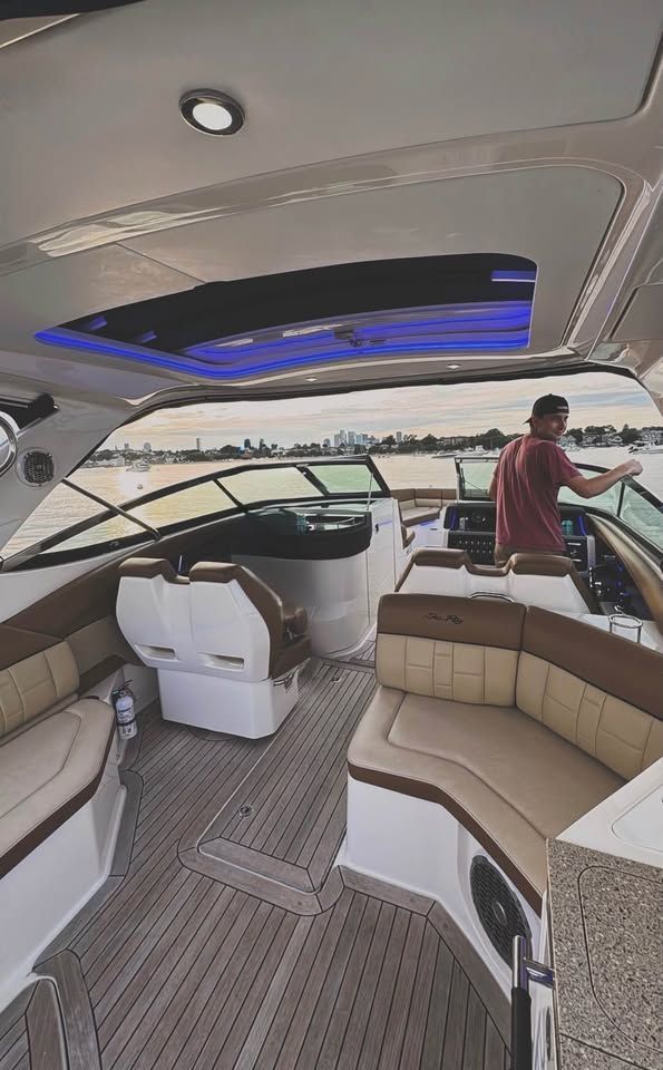 The image shows the cockpit of a 2015 Sea Ray SLX 350 with luxurious seating and a modern helm.