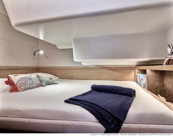 Luxurious interior cabin of 2025 Lagoon 51 ICONIC yacht with modern bedding.