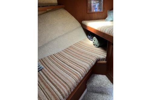 1983 Uniflite Cabin Cruiser interior with striped upholstery and cozy sleeping area.