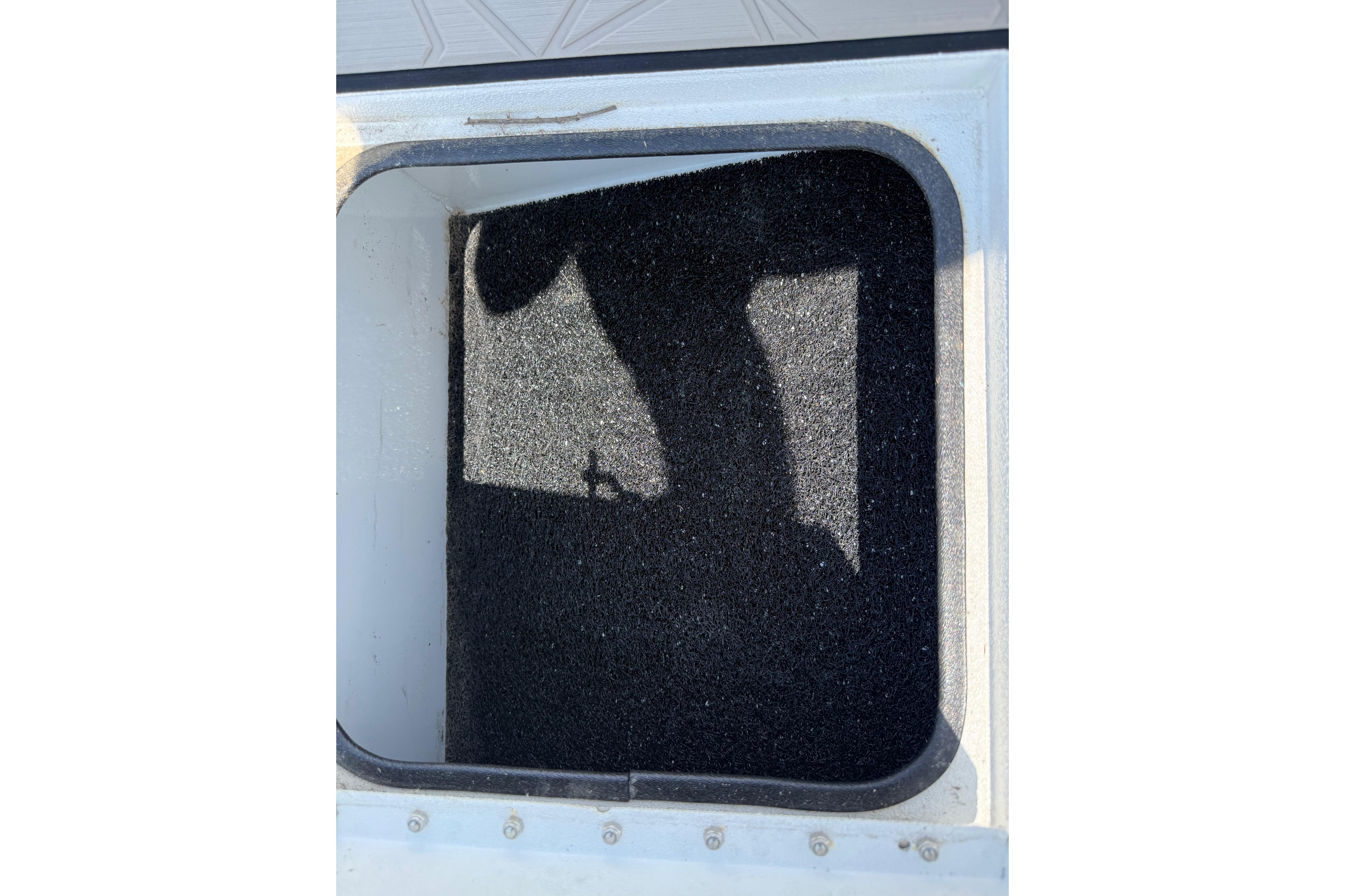 Open storage compartment of 2025 Avid 22 Recon, featuring a textured black interior.
