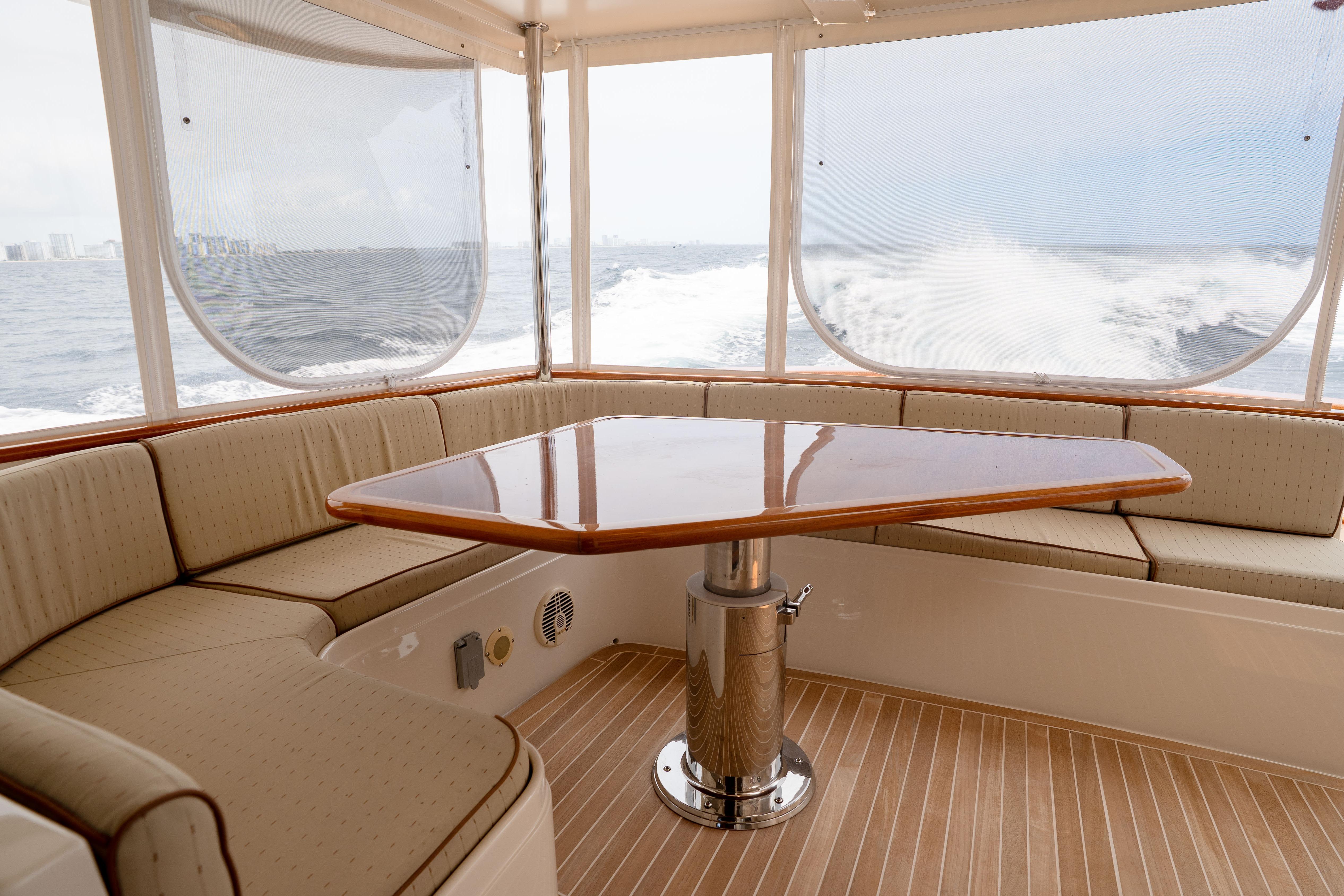 Luxurious interior of 2006 Fleming 75 yacht with ocean view and elegant seating area.