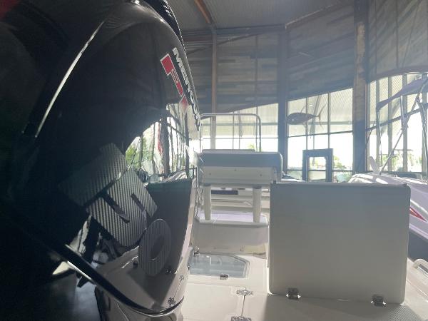 2024 Mako Pro Skiff 19 CC boat interior with engine in showroom.