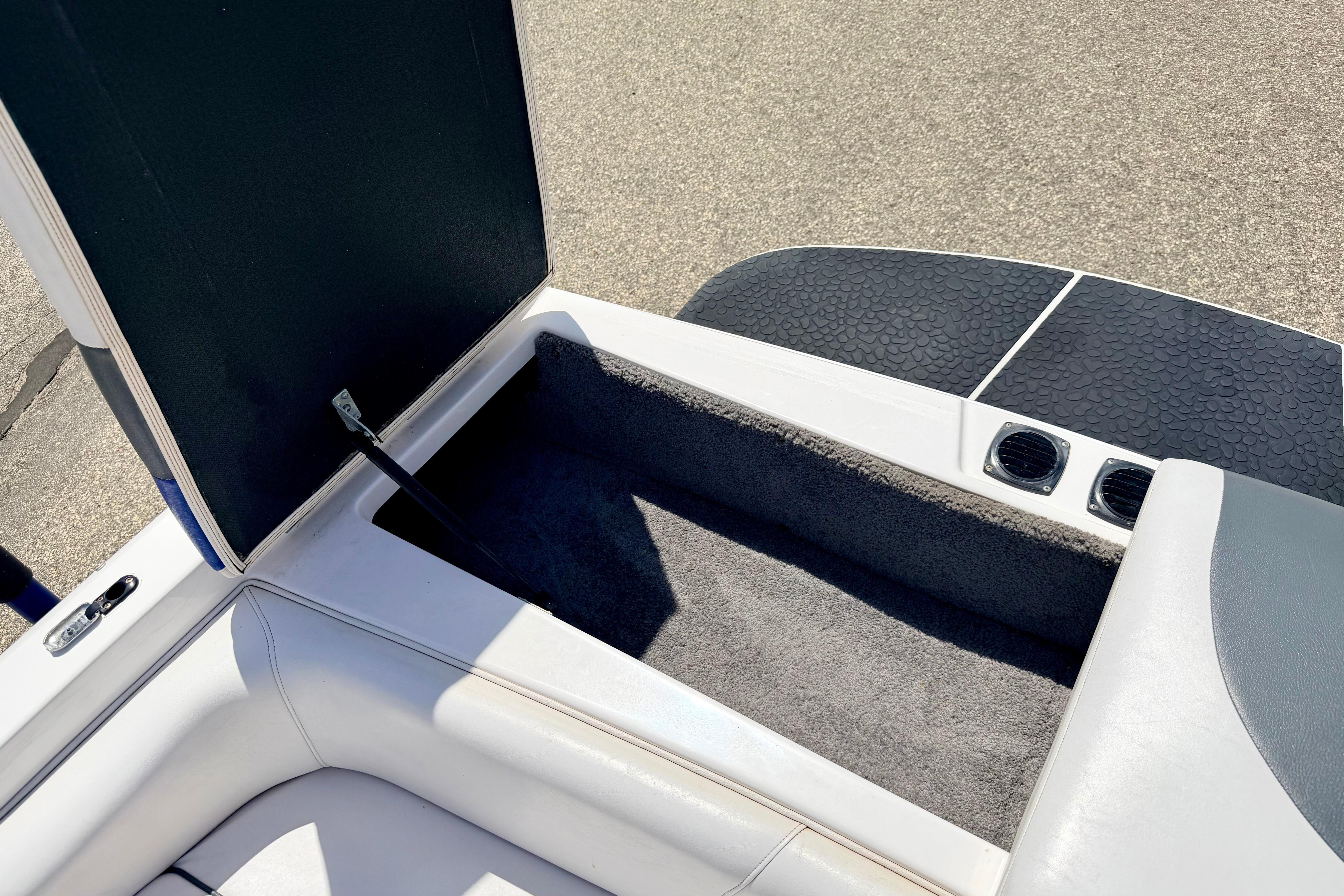 Open storage compartment in 2008 Moomba Outback V boat, featuring cushioned seating and carpeted interior.