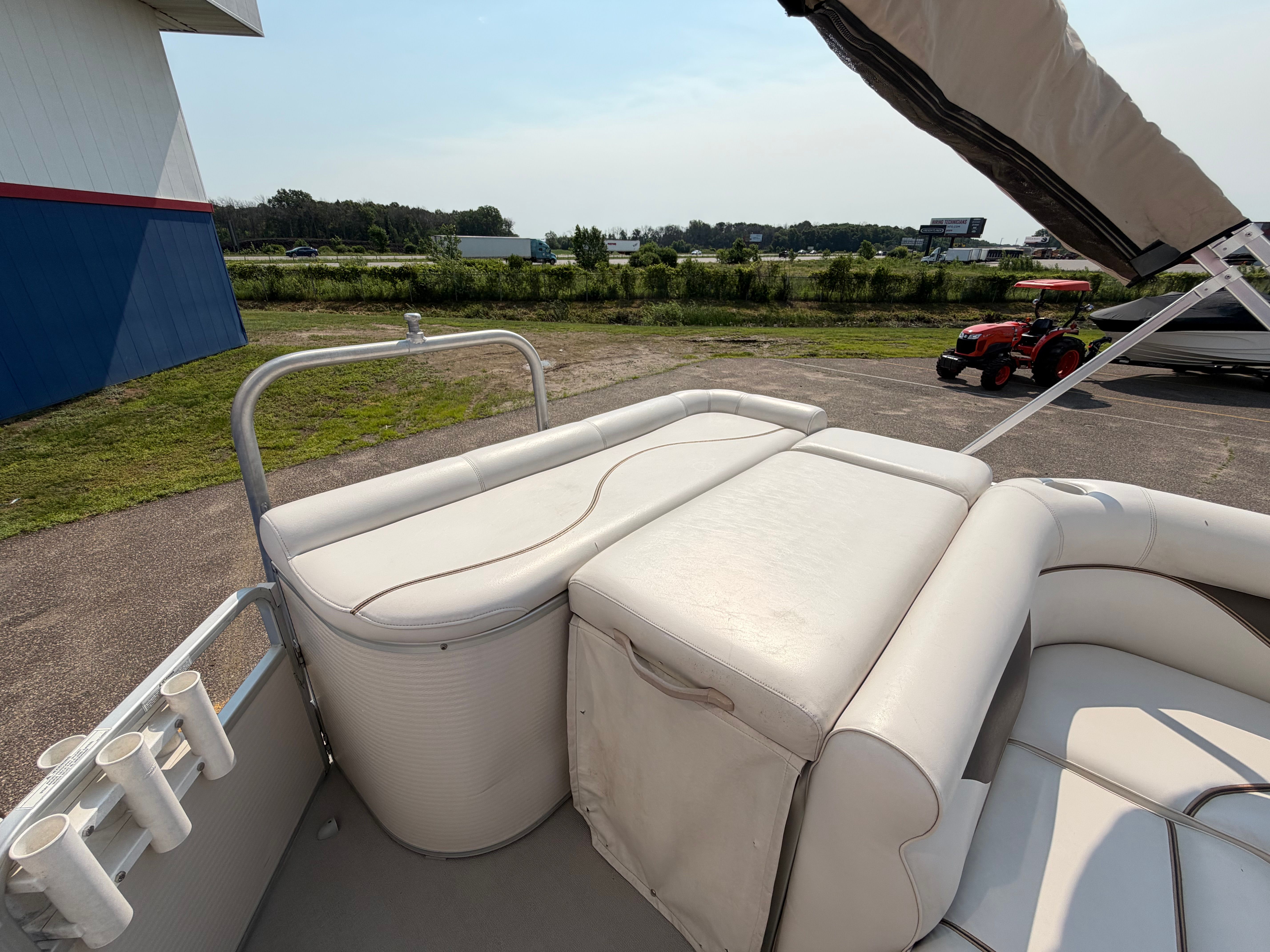 The image shows the deck of a 2007 Premier 225 Sunsation pontoon boat with white upholstery.