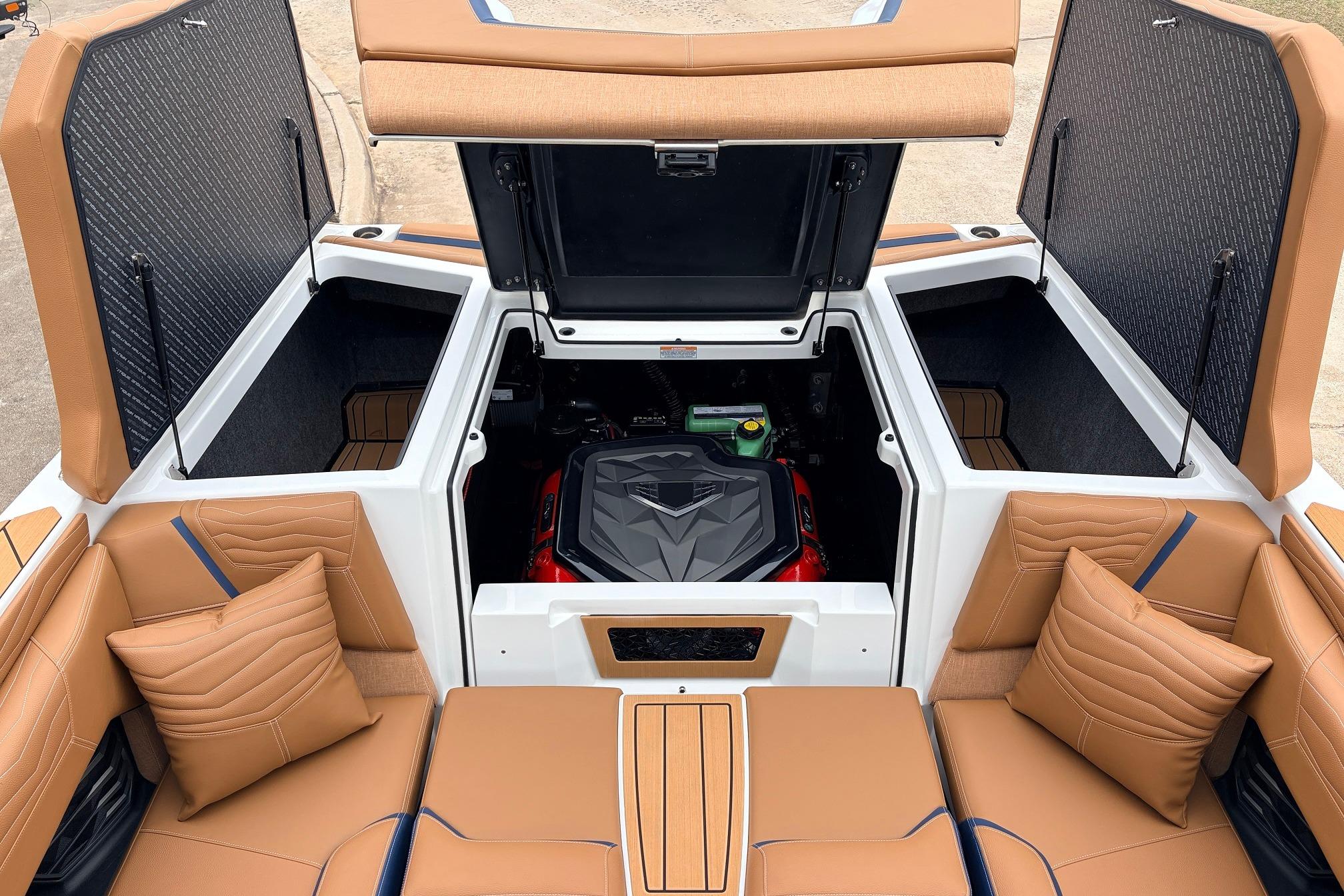 2026 Nautique Super Air Nautique G25 boat interior with open engine compartment and tan seating.