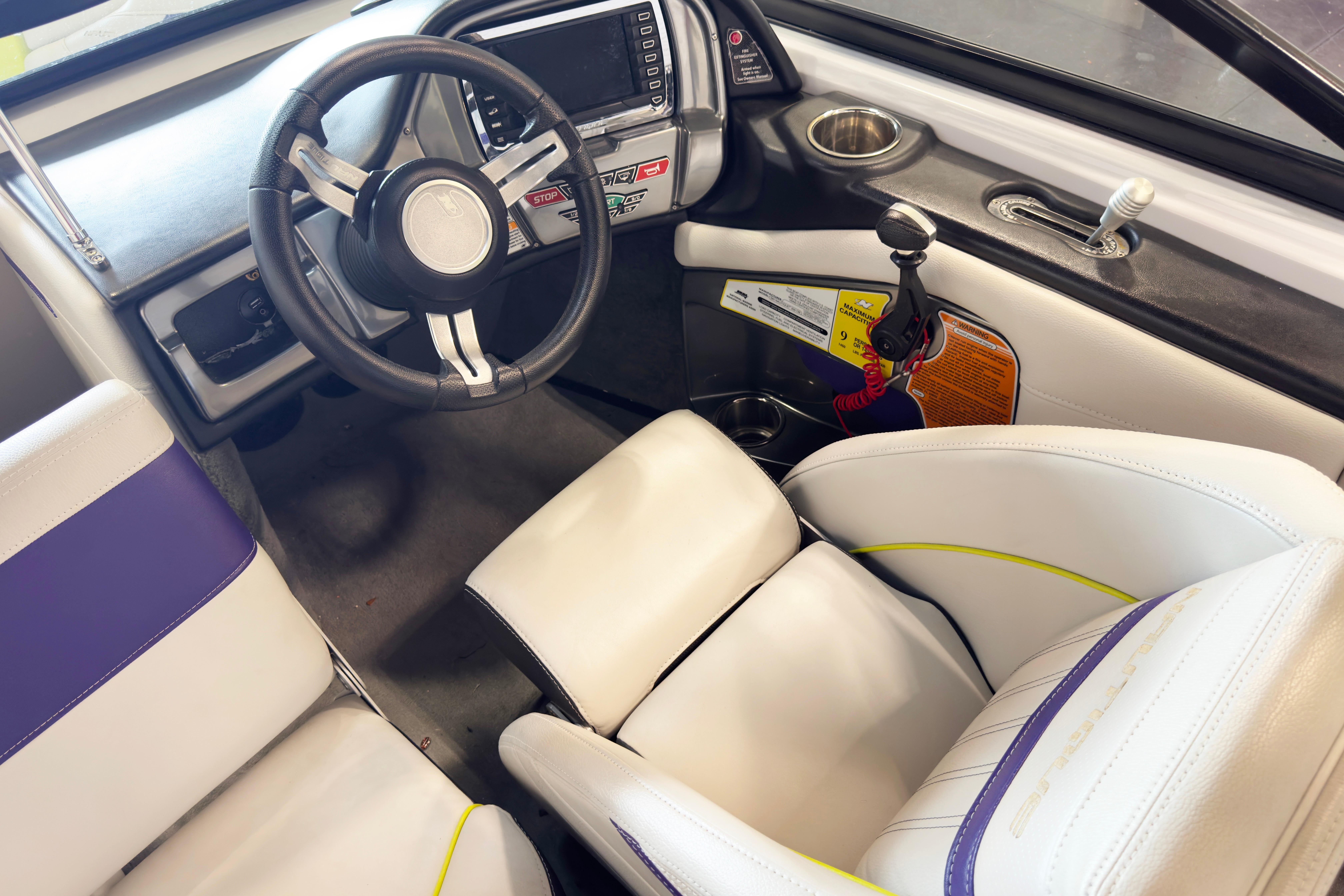 Interior of 2014 Nautique Ski Nautique 200 Closed Bow boat with steering wheel and seating.