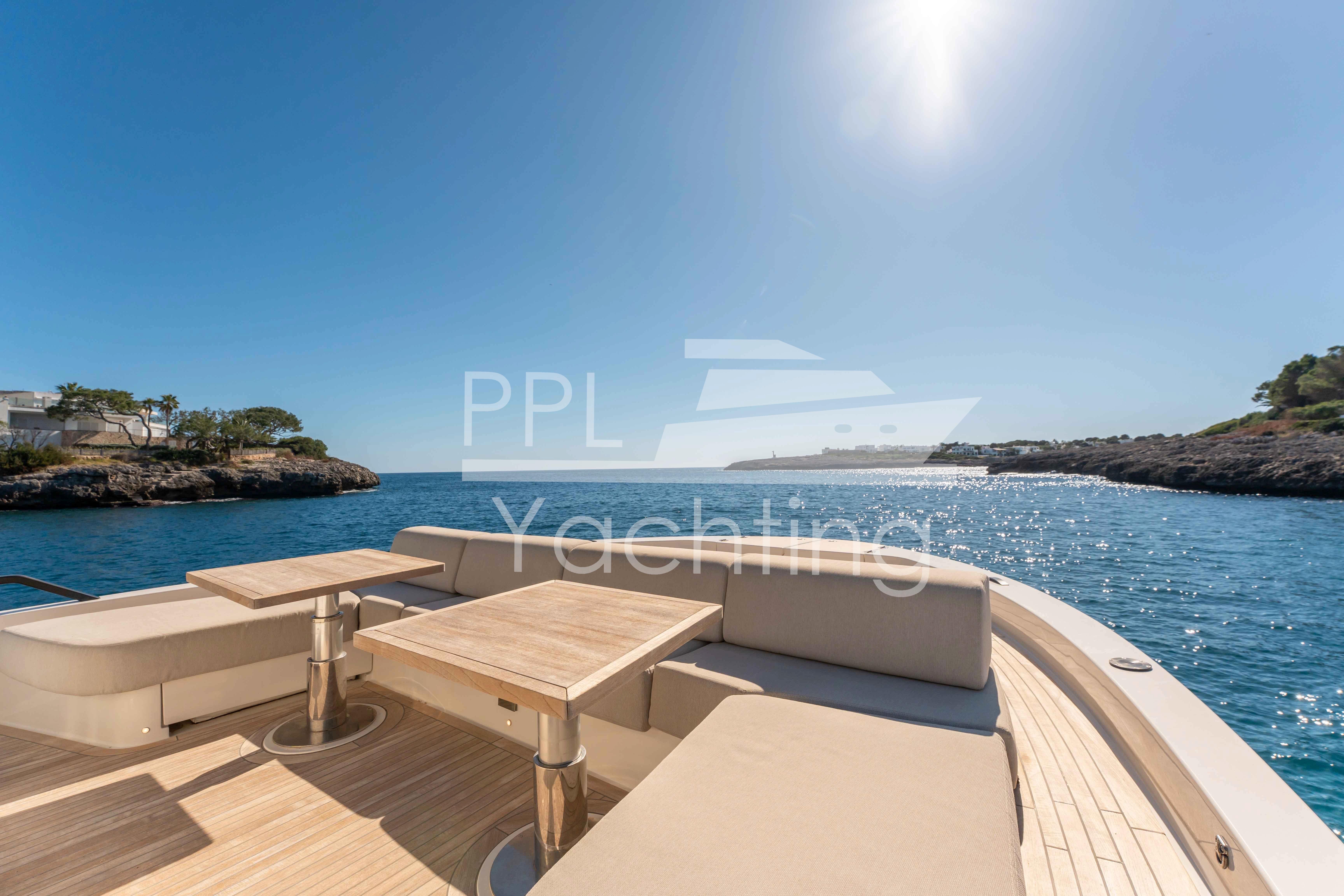2024 Bluegame BGX63 yacht deck with seating, tables, and scenic ocean view.