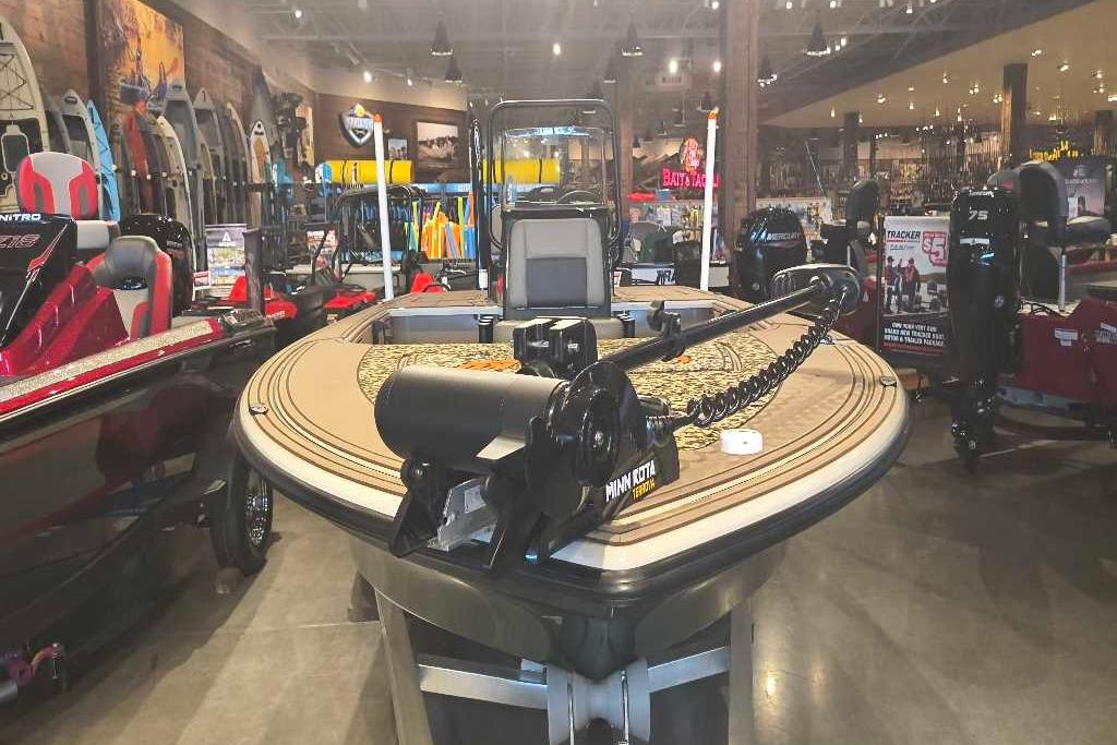 2026 Mako 18 Pro Skiff Backwater Edition displayed in a showroom with boating equipment.