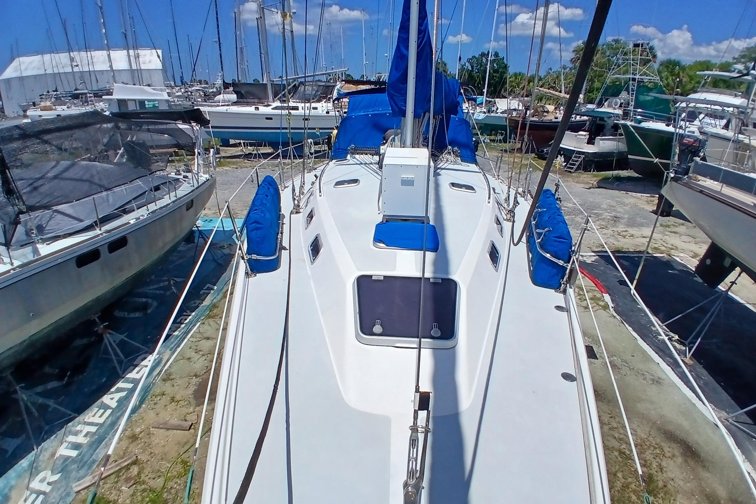 Catalina 42 MkII sailboat from 1995 docked in a marina, surrounded by other boats.