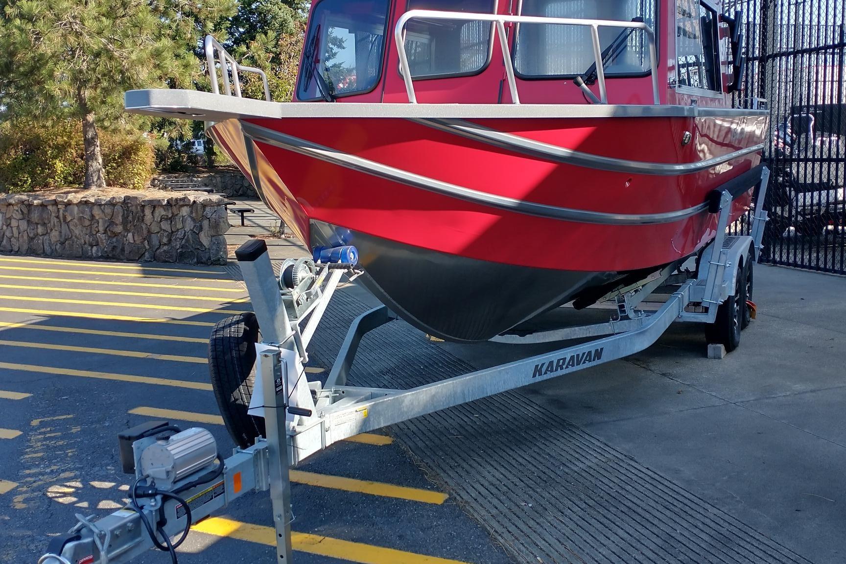 2024 Spartan 220 Maximus Pro boat on Karavan trailer, parked outdoors.