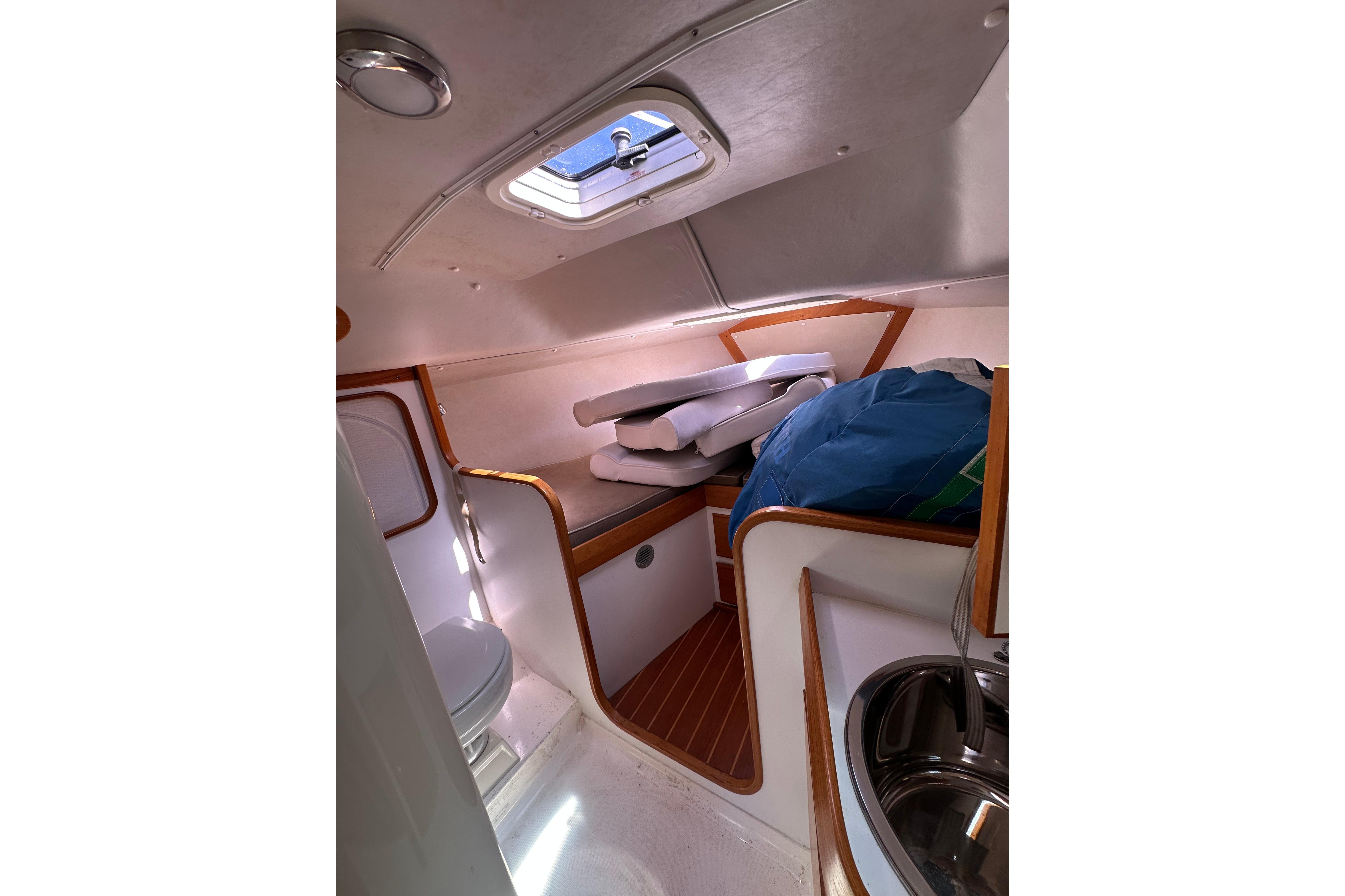 Interior cabin of 2011 Alerion Sport 33 sailboat with cushions and porthole.