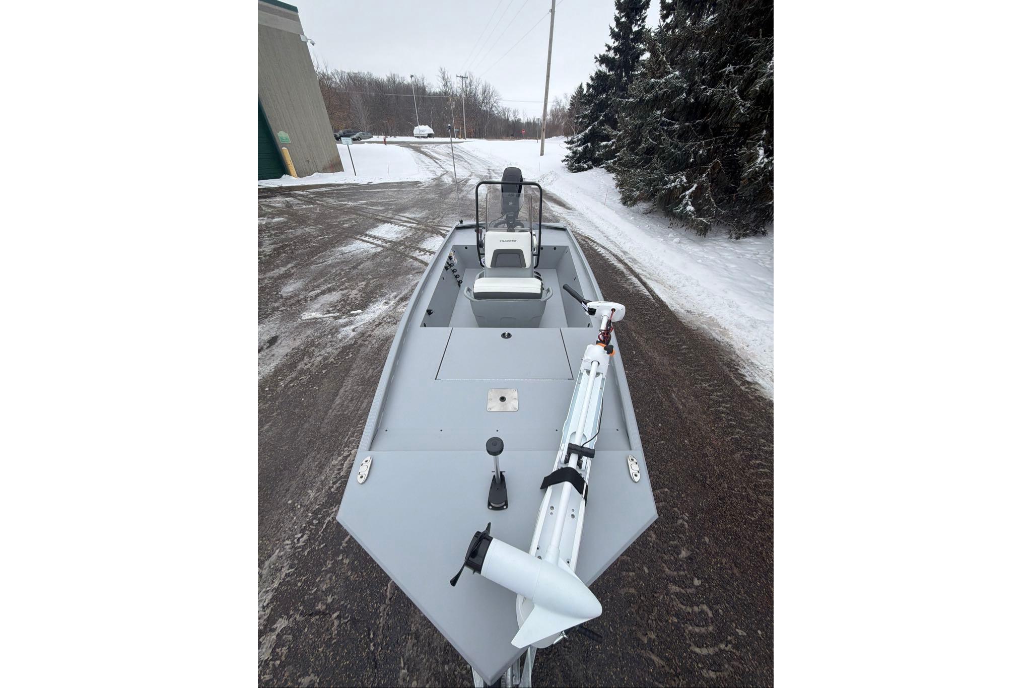 2026 Tracker Bass Tracker Classic CC boat on snowy road, showcasing sleek design.