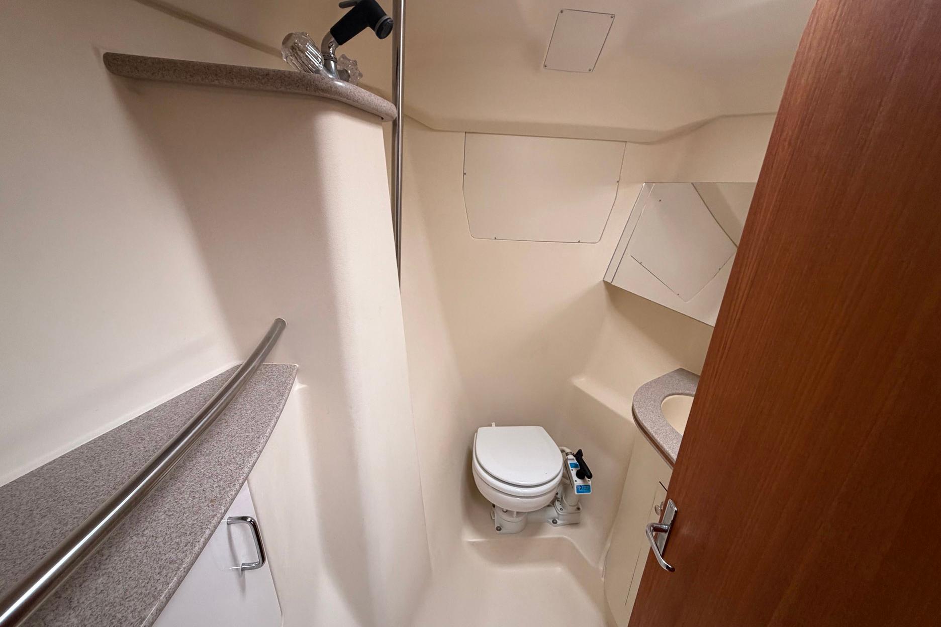1998 Hunter 410 yacht bathroom with toilet, sink, and storage cabinets.