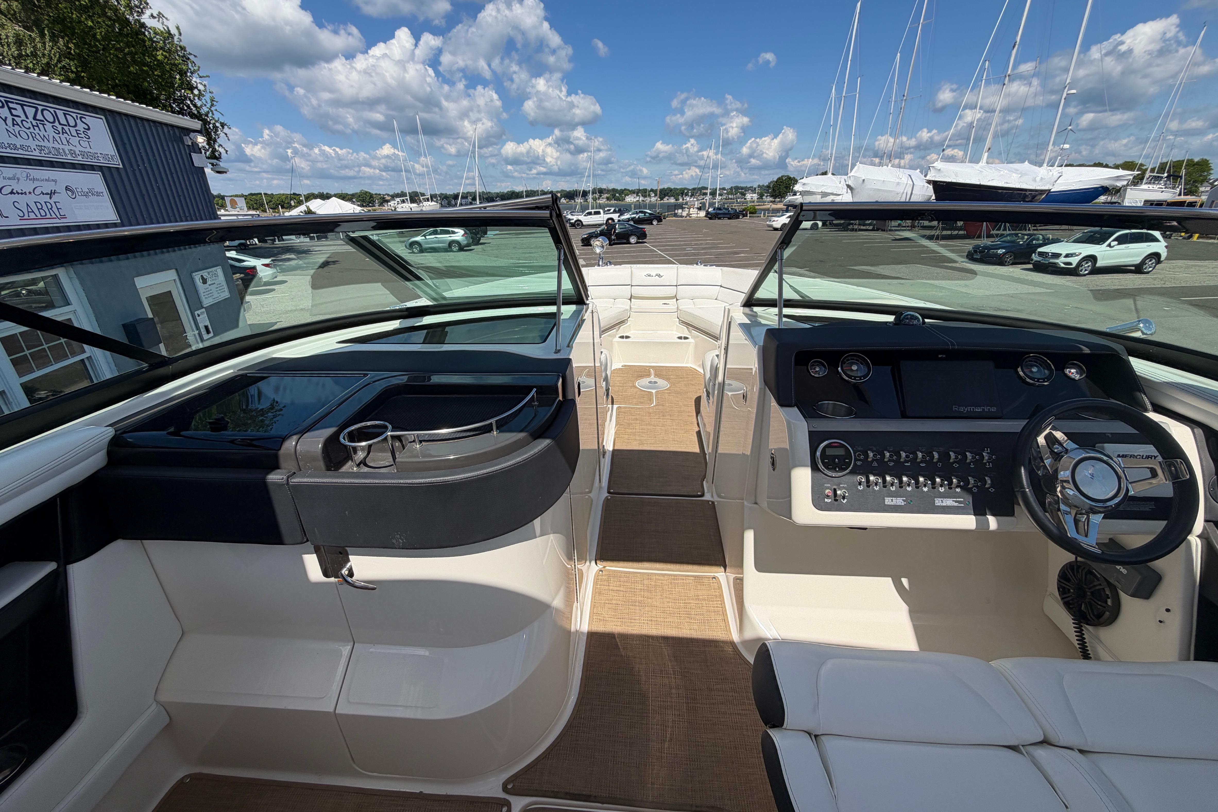2015 Sea Ray SLX 350 boat interior with steering wheel and dashboard, docked under a sunny sky.