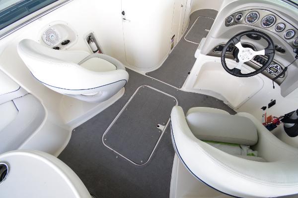 Interior of a 2010 Bryant 255 boat with white seating and a helm station.