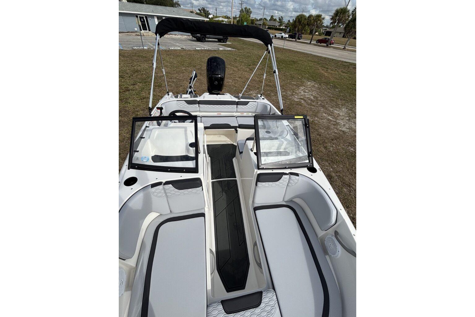 2025 Bayliner Element M17 boat interior with seating and windshield, parked outdoors.