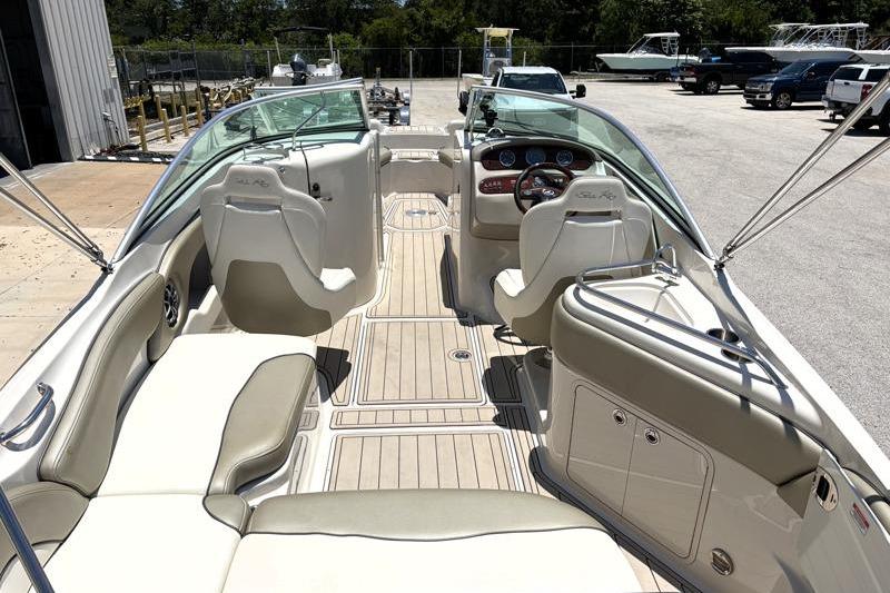 2007 Sea Ray 240 Sundeck interior with beige seating and sleek dashboard design.