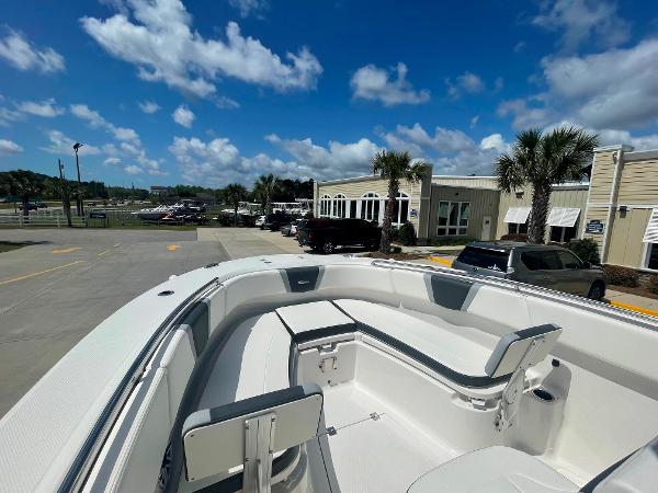 2023 Robalo R270 boat with spacious seating, docked at a marina under a clear blue sky.