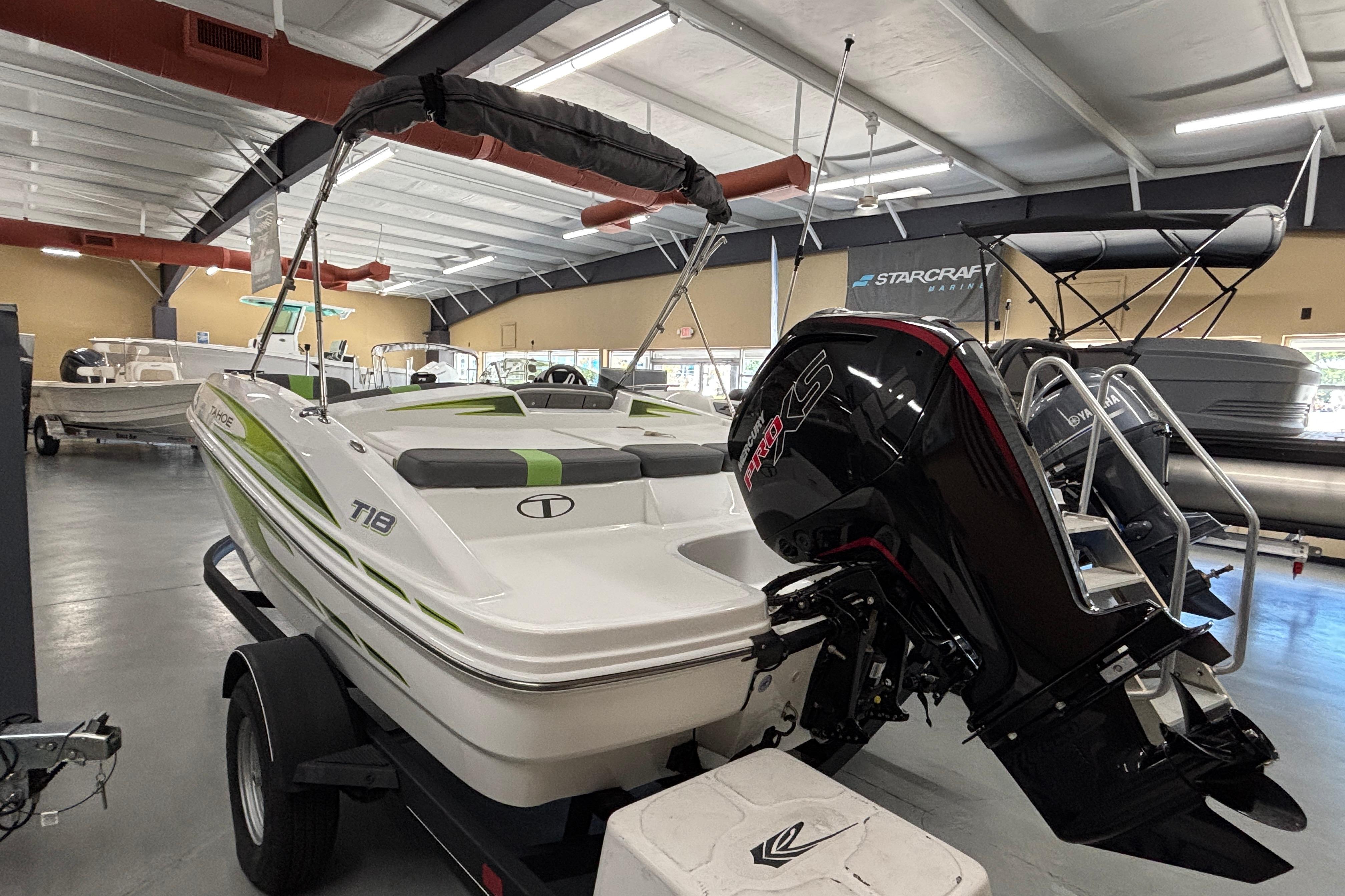 2024 Tahoe T18 boat with outboard motor displayed in a showroom.