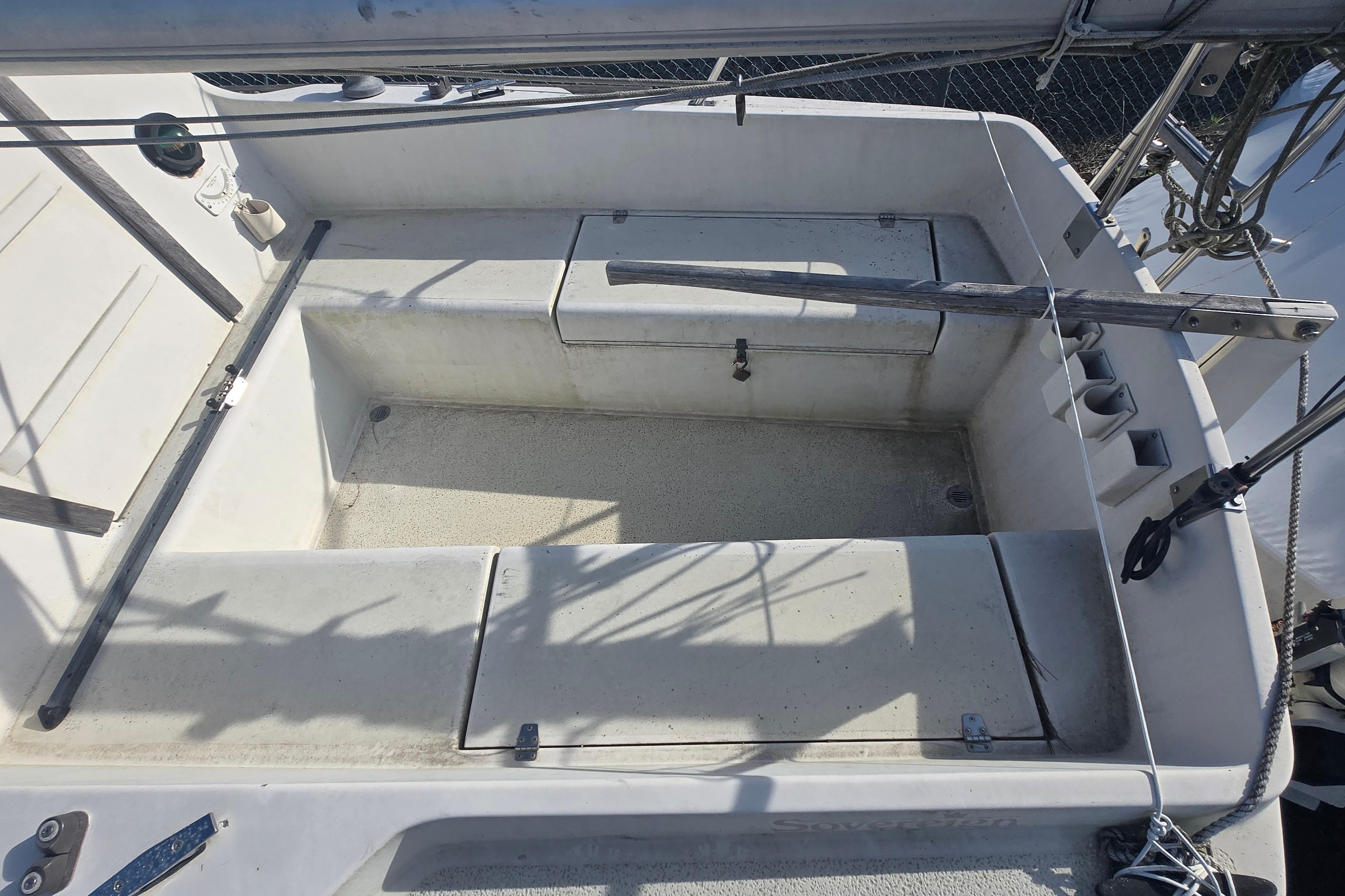 Cockpit of a 1986 Sovereign 24 sailboat, featuring seating and storage compartments.
