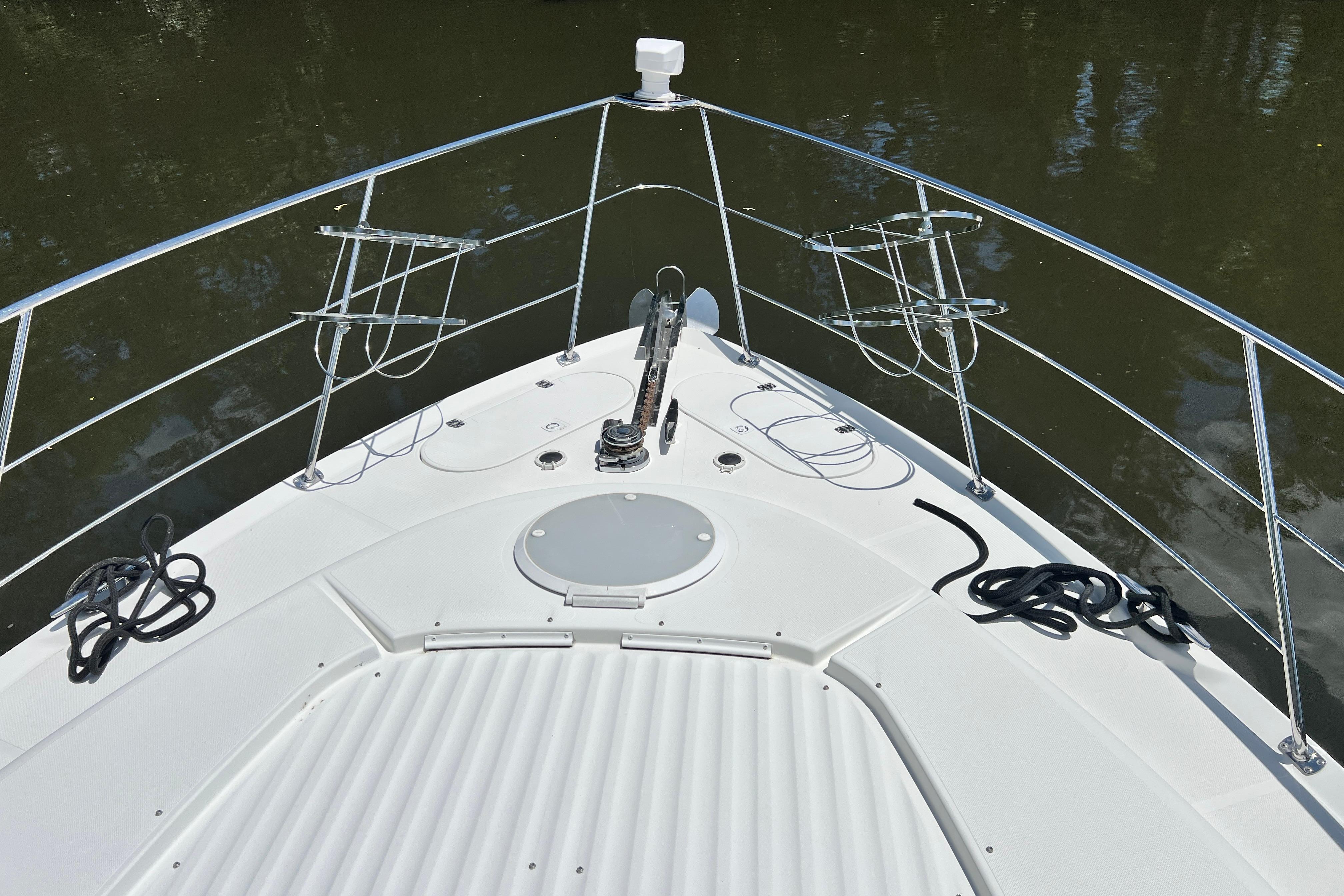 Bow view of 2003 Carver 450 Voyager Pilothouse yacht with railing and anchor.