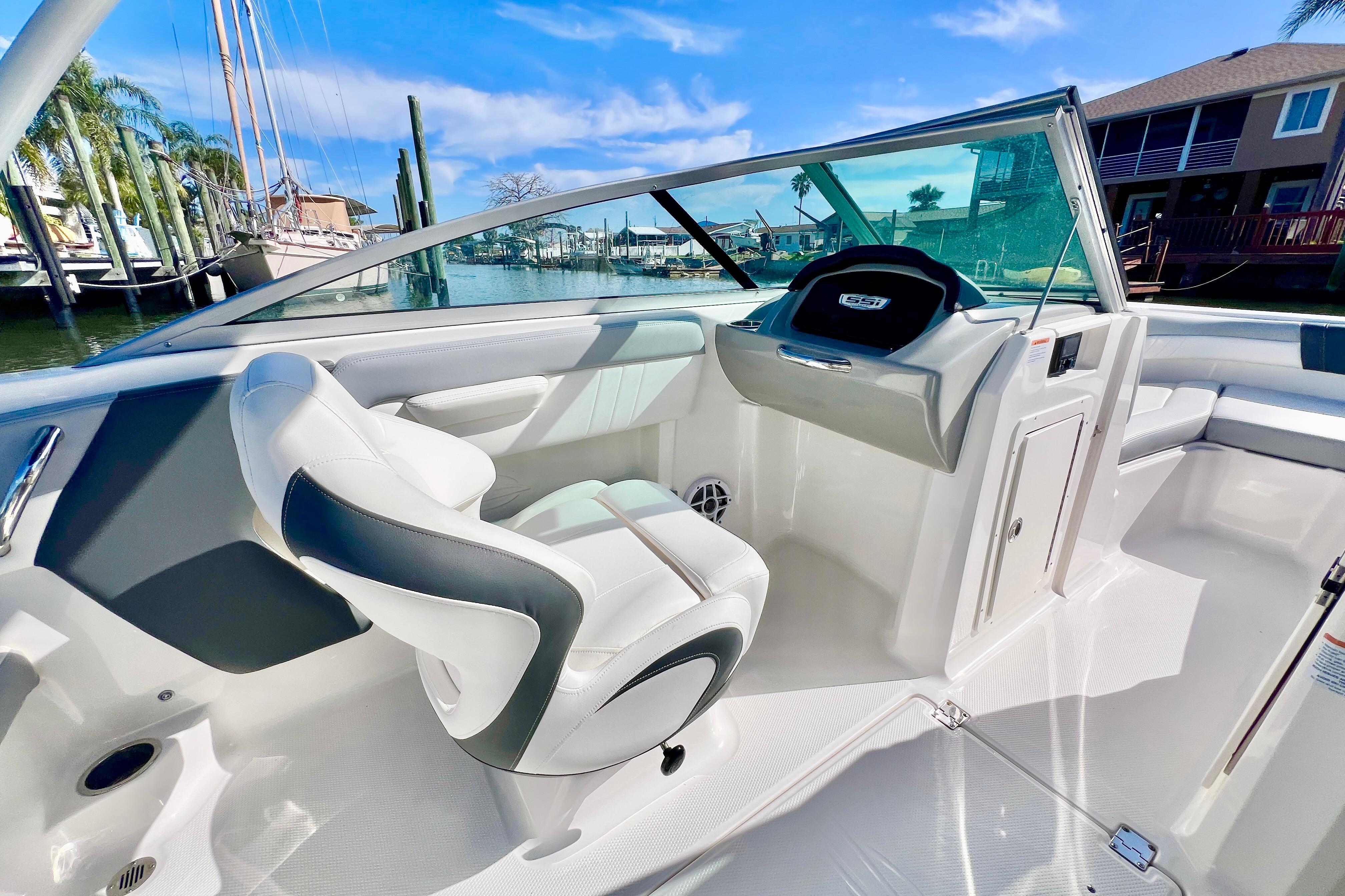 2023 Chaparral 21 SSi OB boat interior with sleek white seating and modern dashboard.