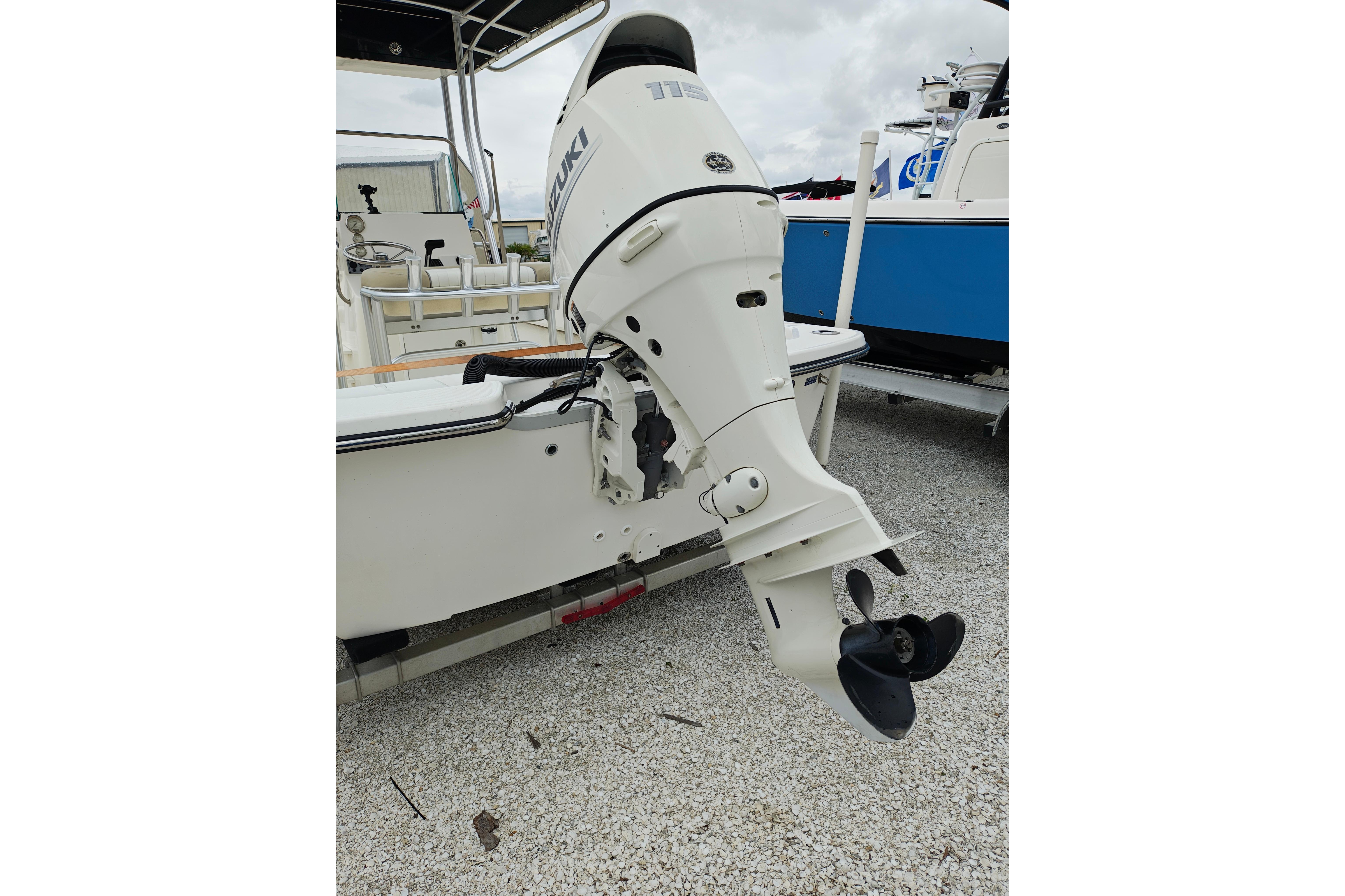 2018 Sundance B20CCR boat with Suzuki outboard motor on gravel surface.