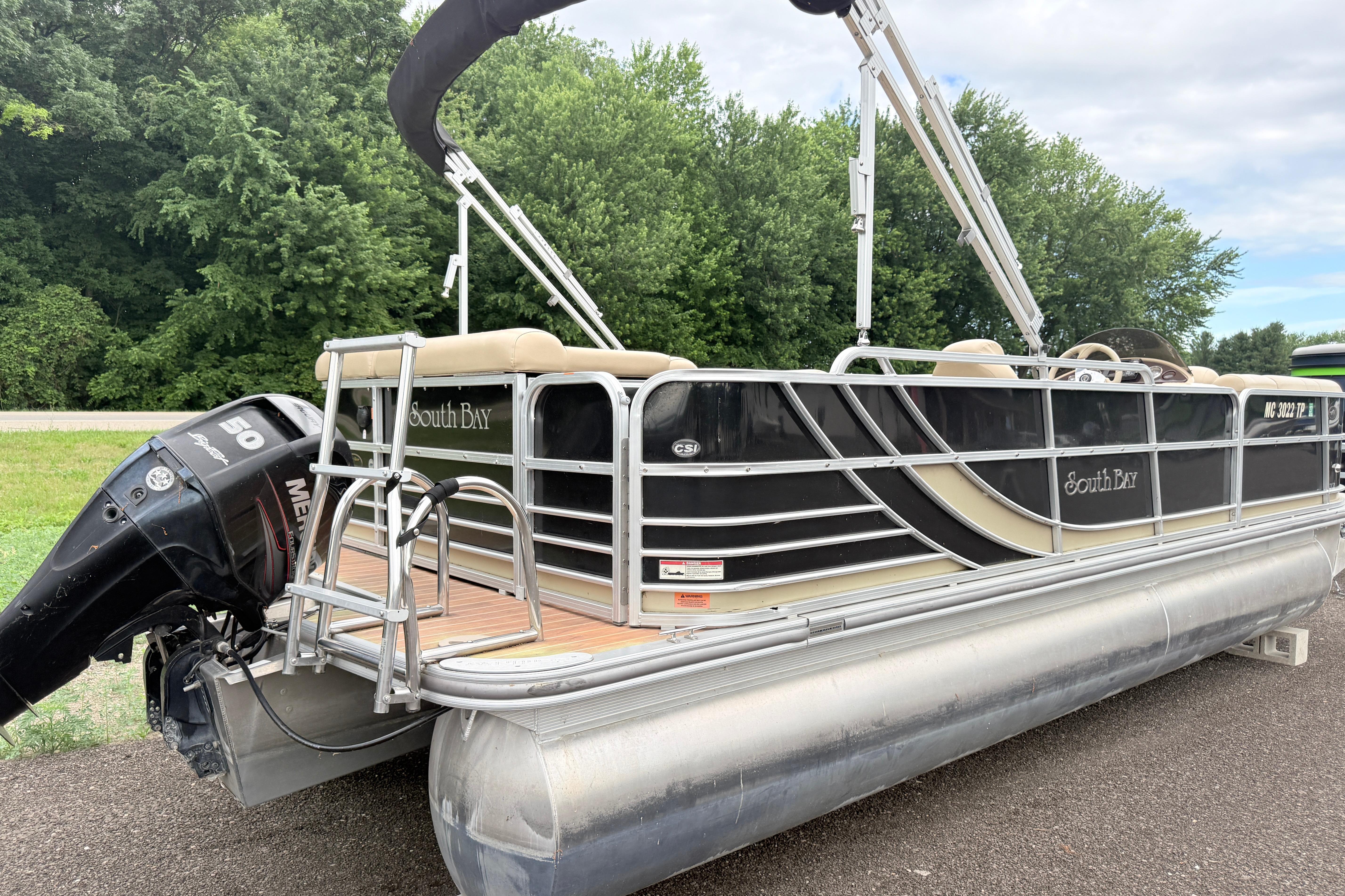 2013 South Bay 522CR pontoon boat with Mercury 50 engine, parked on a road.