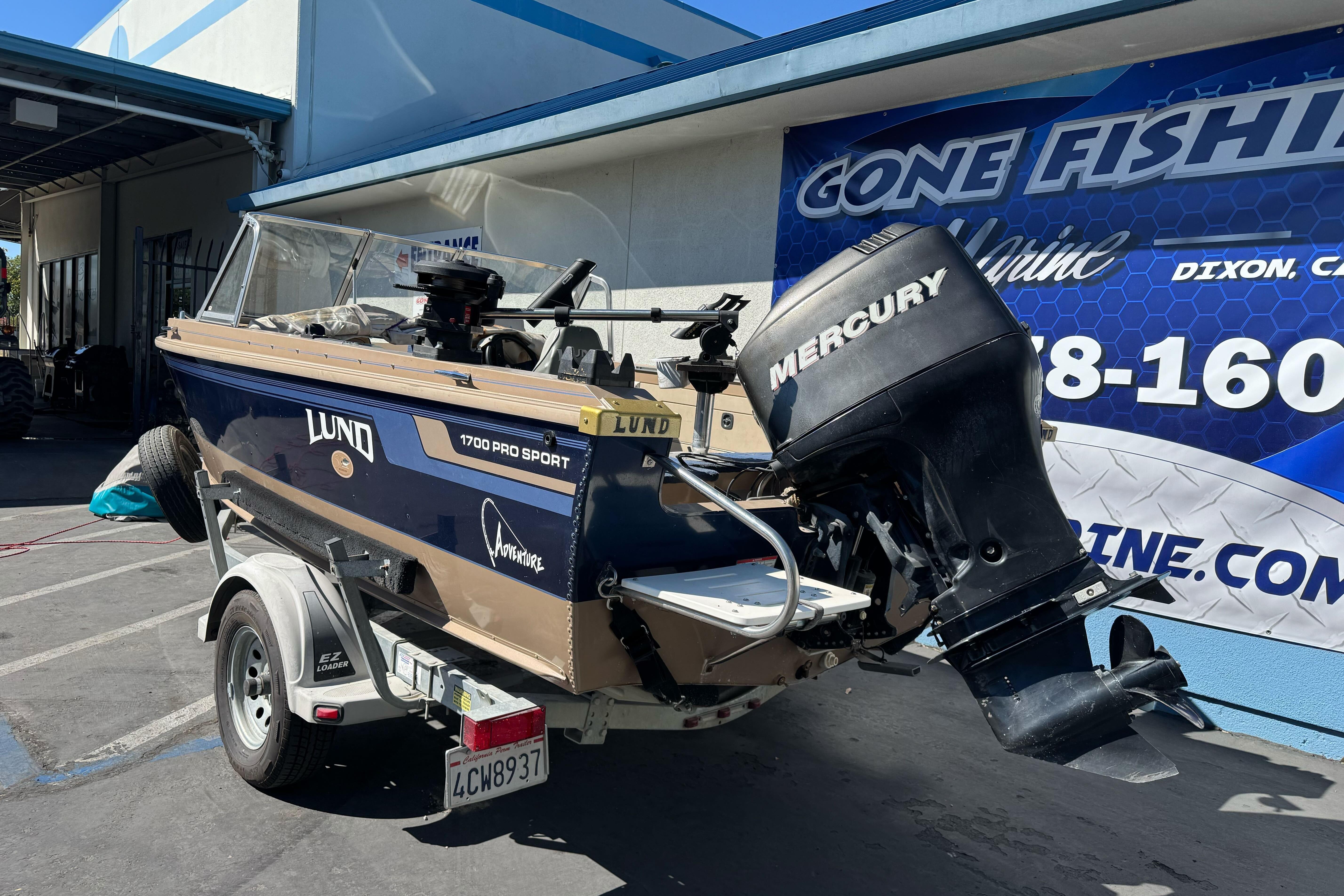 1998 Lund 1700 Pro Sport boat with Mercury outboard motor on trailer.