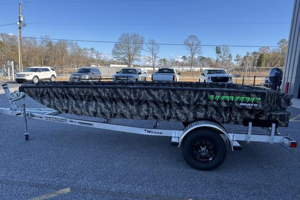 2025 Havoc 1860 boat with camouflage design on a trailer in a parking lot.