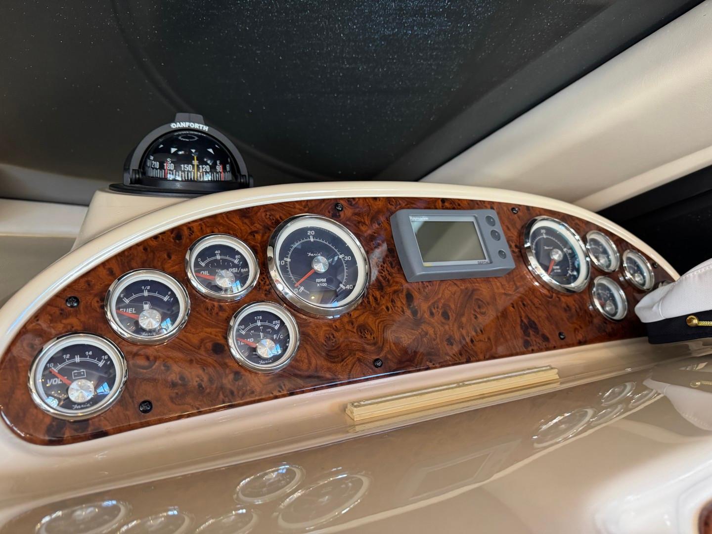 Dashboard of a 2003 Meridian 381 Sedan boat with gauges and compass.