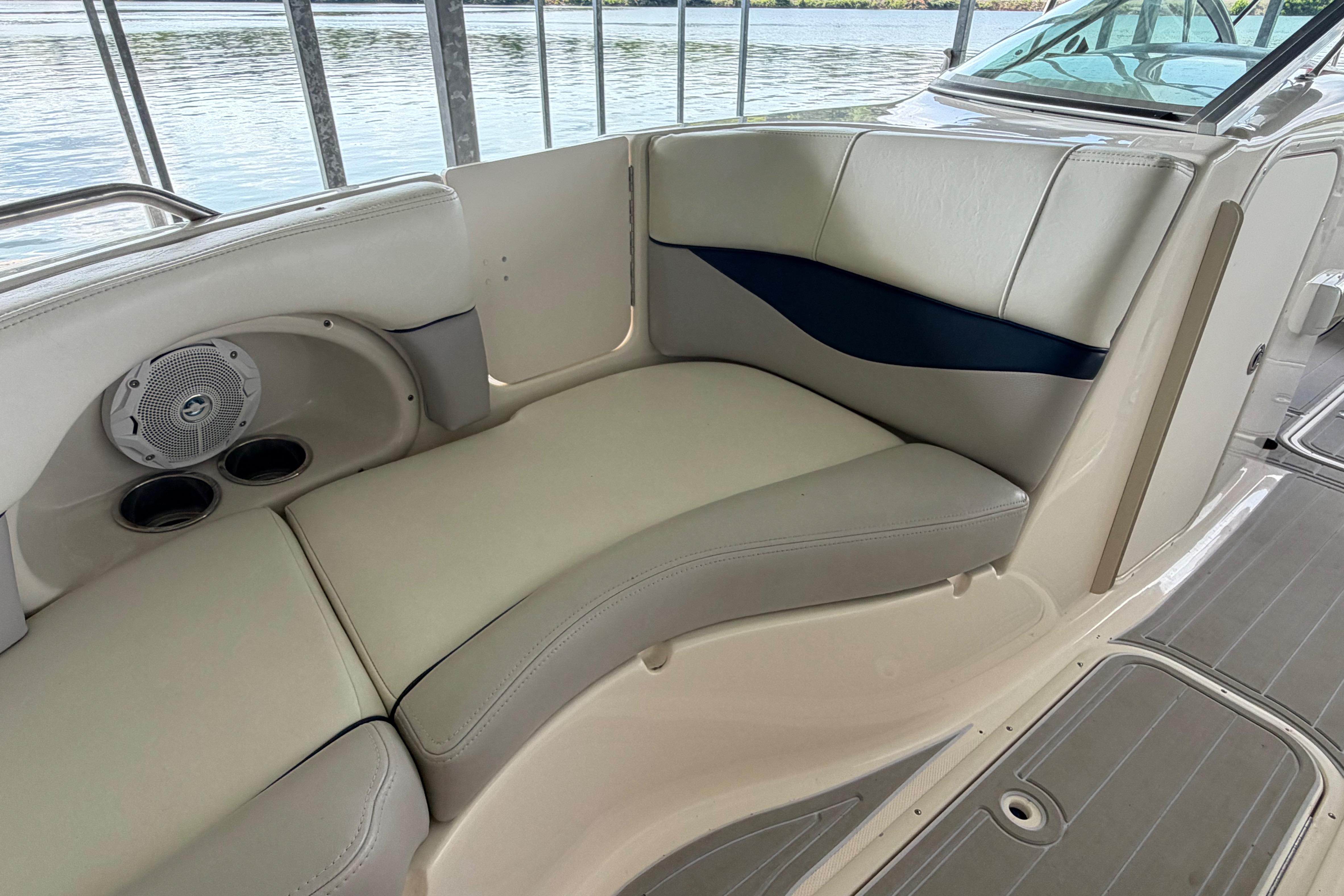 Interior seating of a 2010 Bryant 255 boat, featuring cushioned seats and built-in speakers.