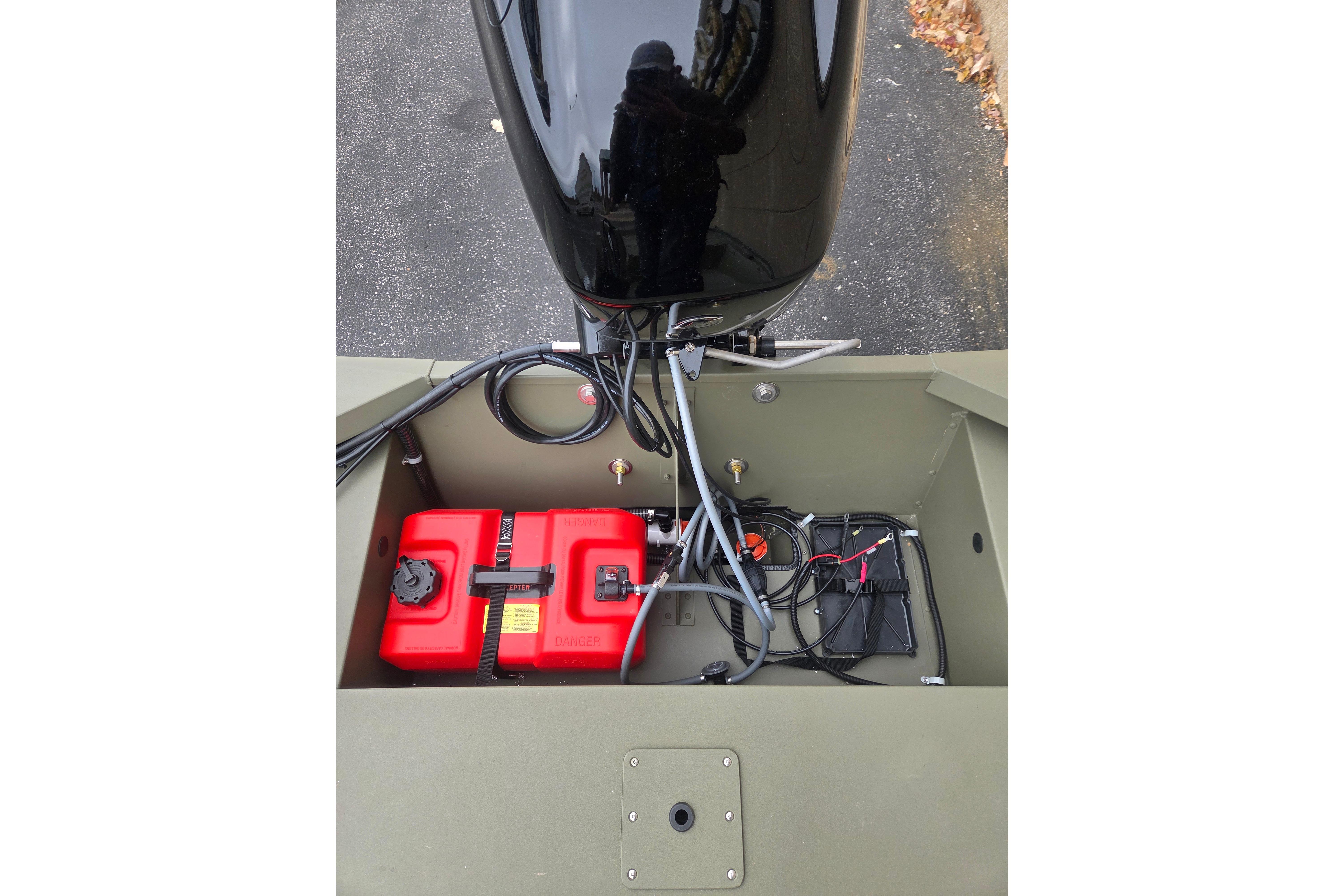 2026 Tracker Grizzly 1648 SC boat engine compartment with red fuel tanks and wiring.