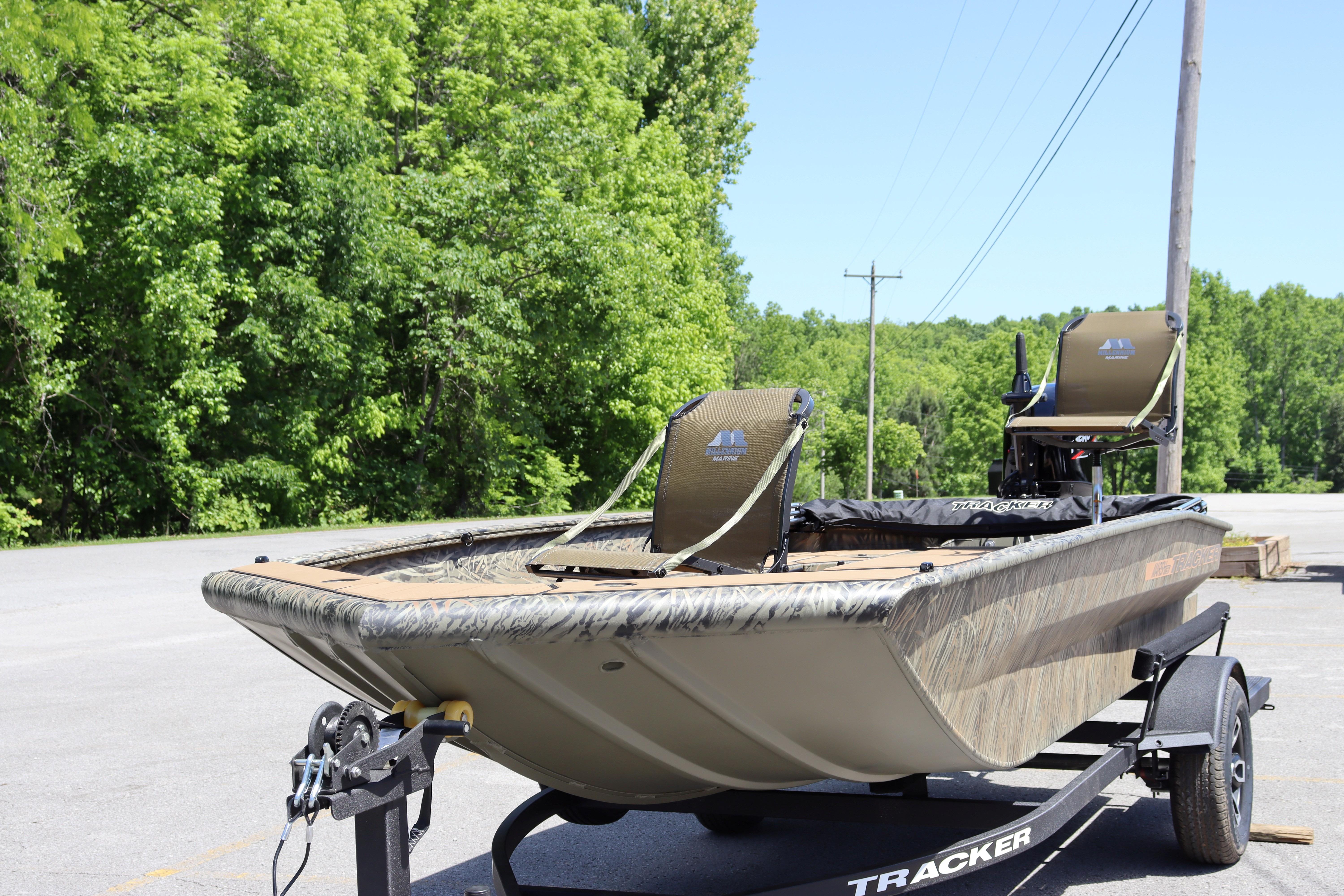 2026 Tracker Grizzly 1756 T Marsh boat on trailer, surrounded by lush greenery.