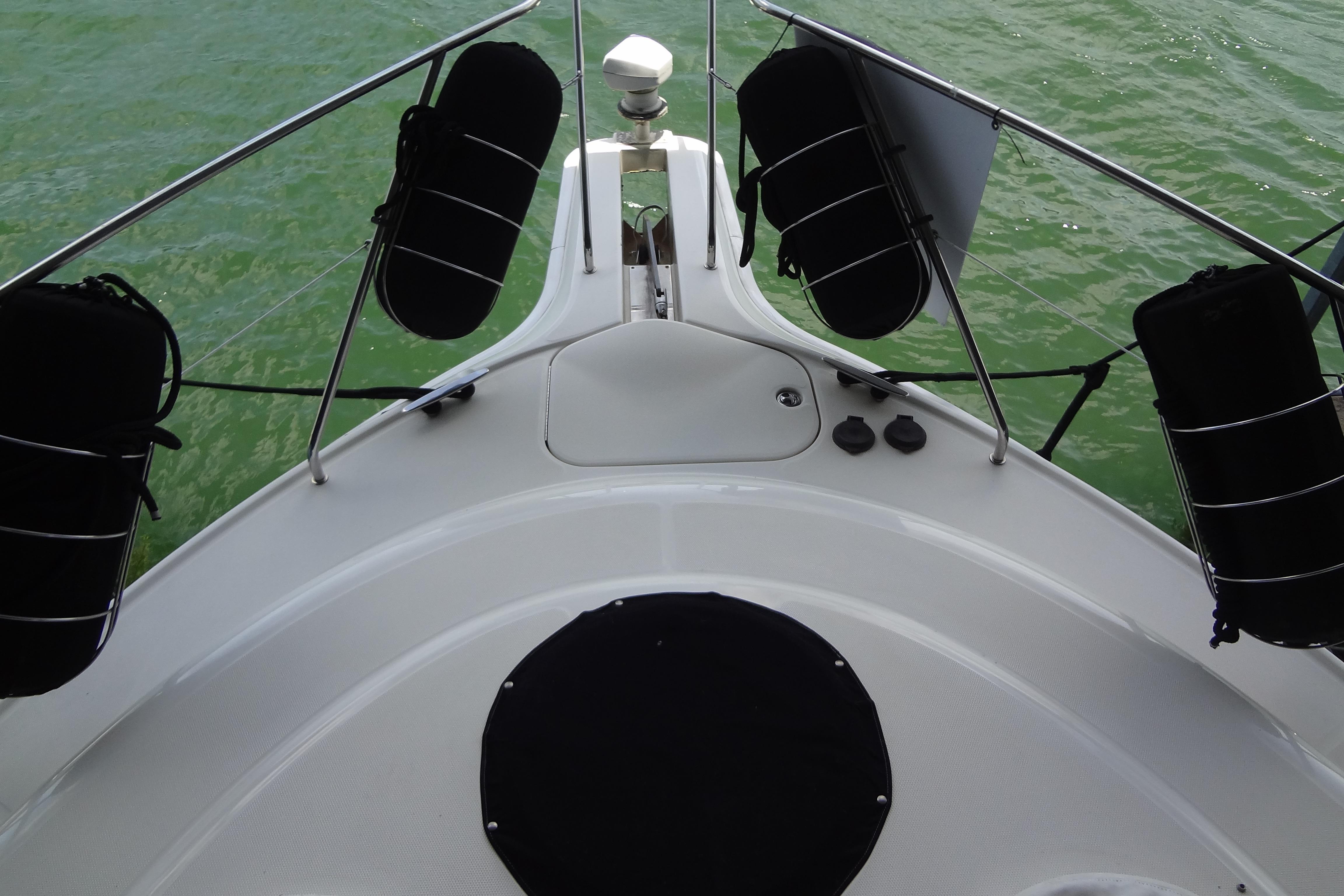 Bow view of 2005 Silverton 34 Convertible yacht on green water.