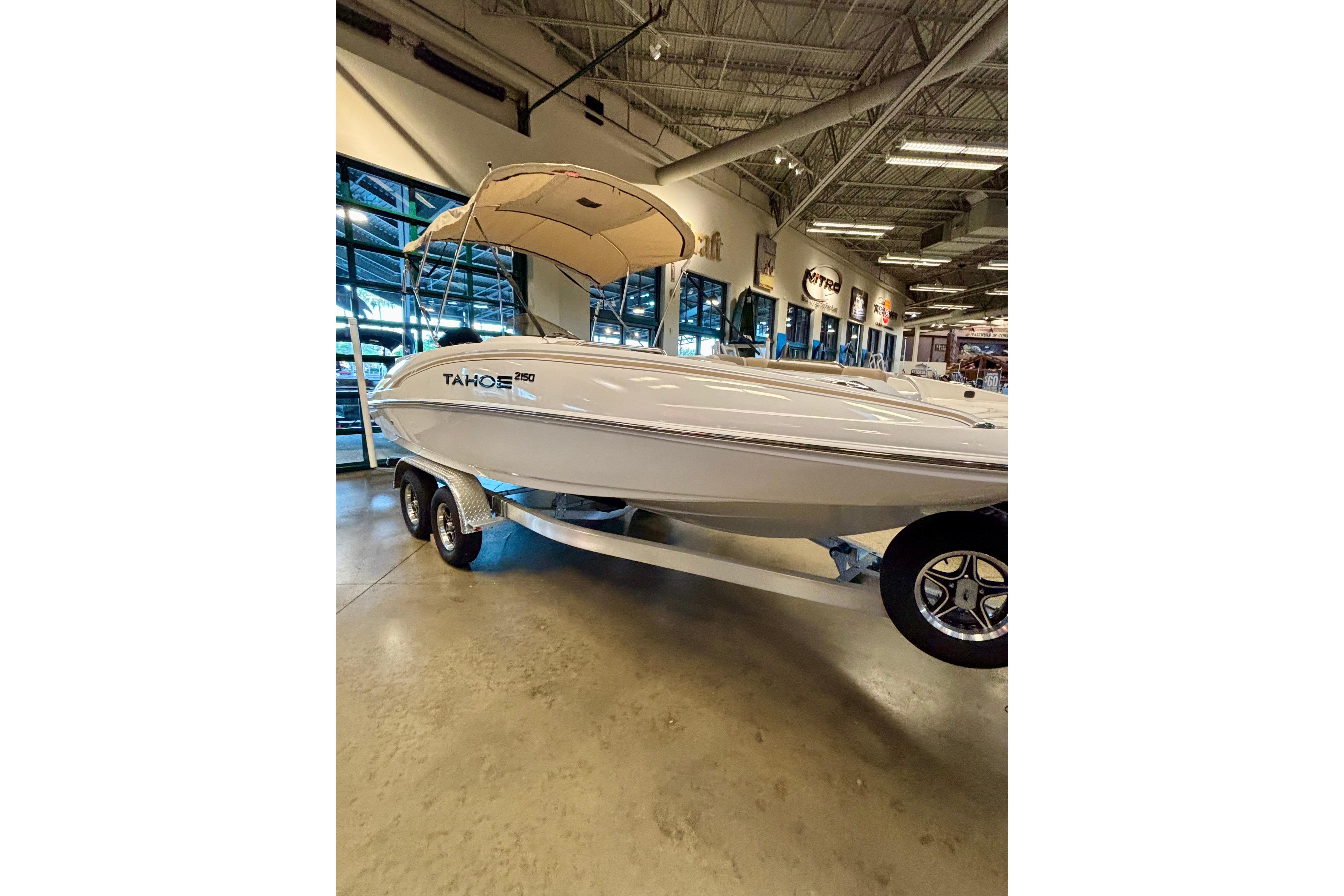 2026 Tahoe 2150 boat displayed indoors with canopy and trailer.