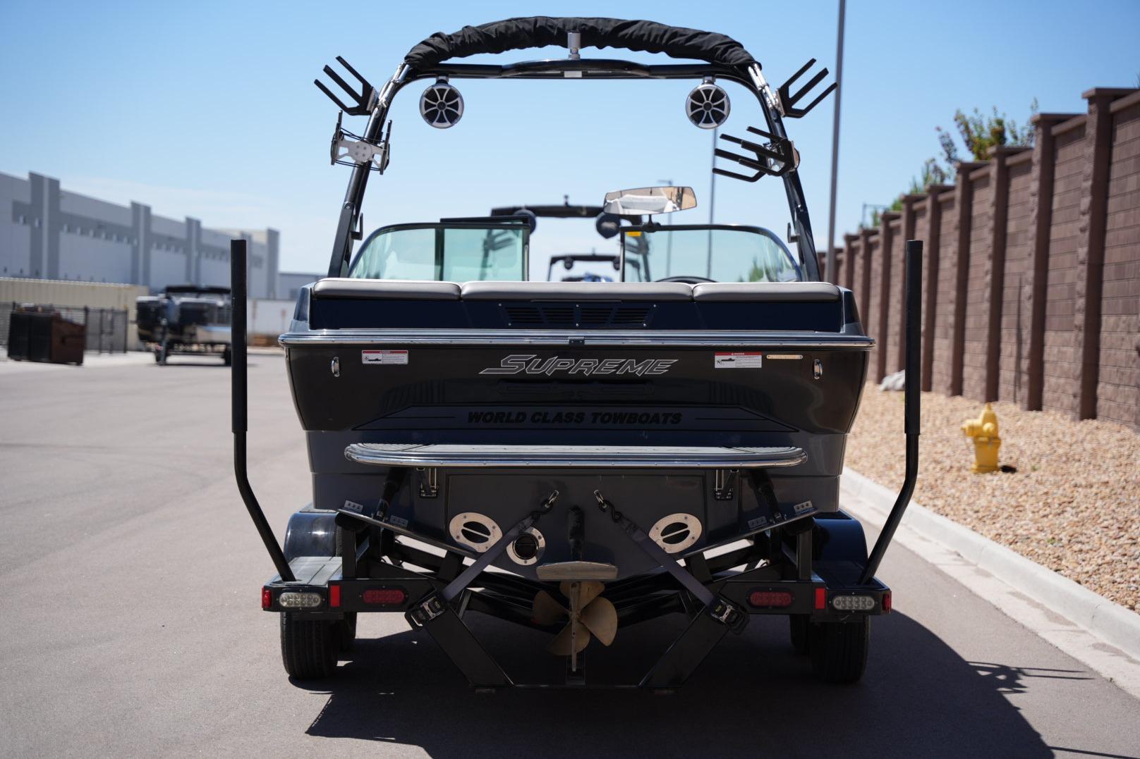 2016 Supreme S211 boat rear view, parked on a sunny street.