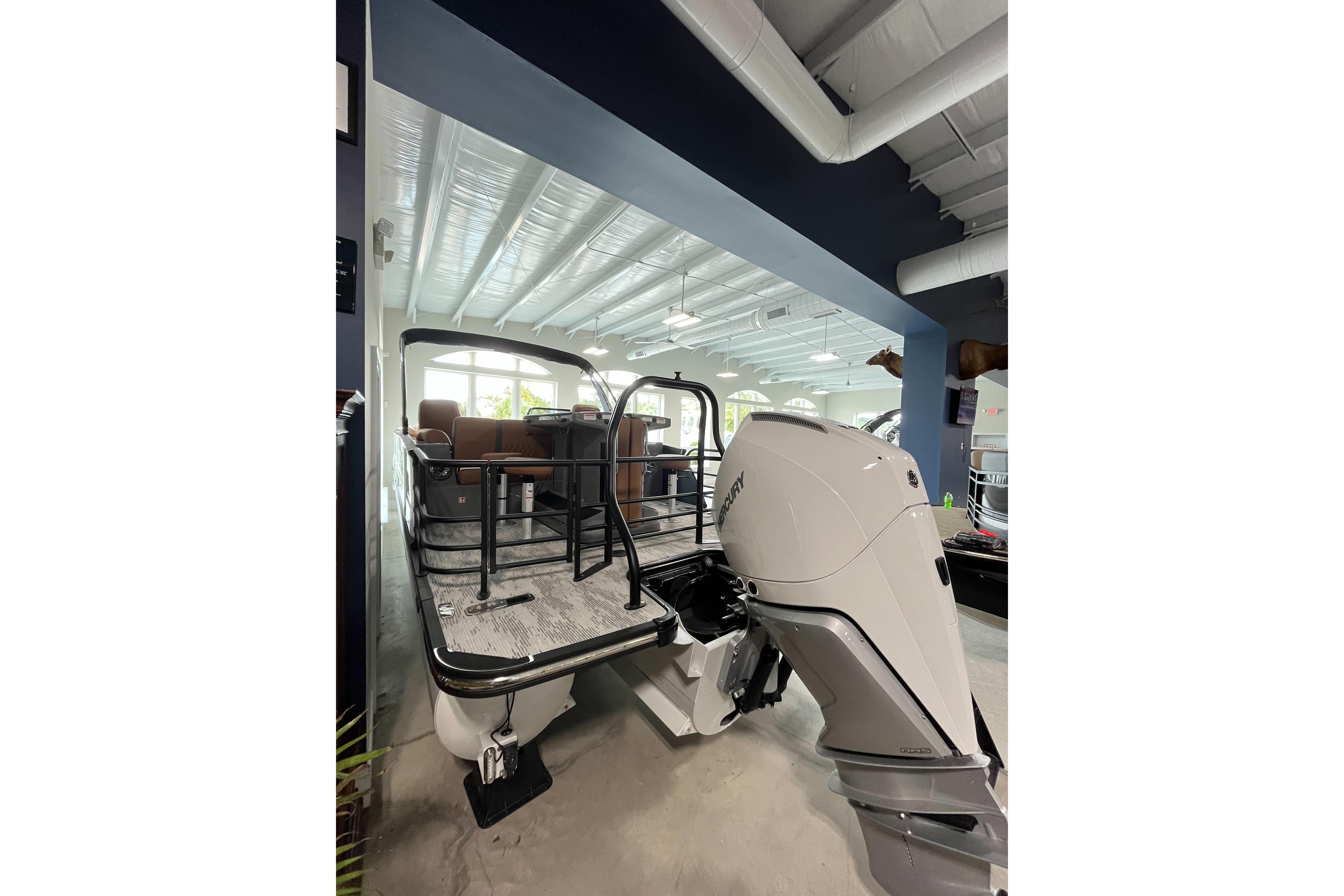 2026 Starcraft RX 25 DL DC boat with powerful outboard motor in showroom.
