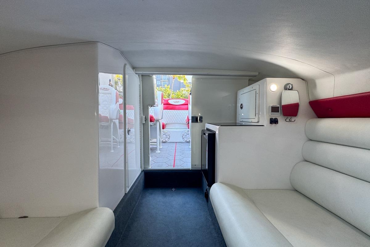 Interior of 2022 Velocity 290sc boat, featuring white seating and compact cabin amenities.