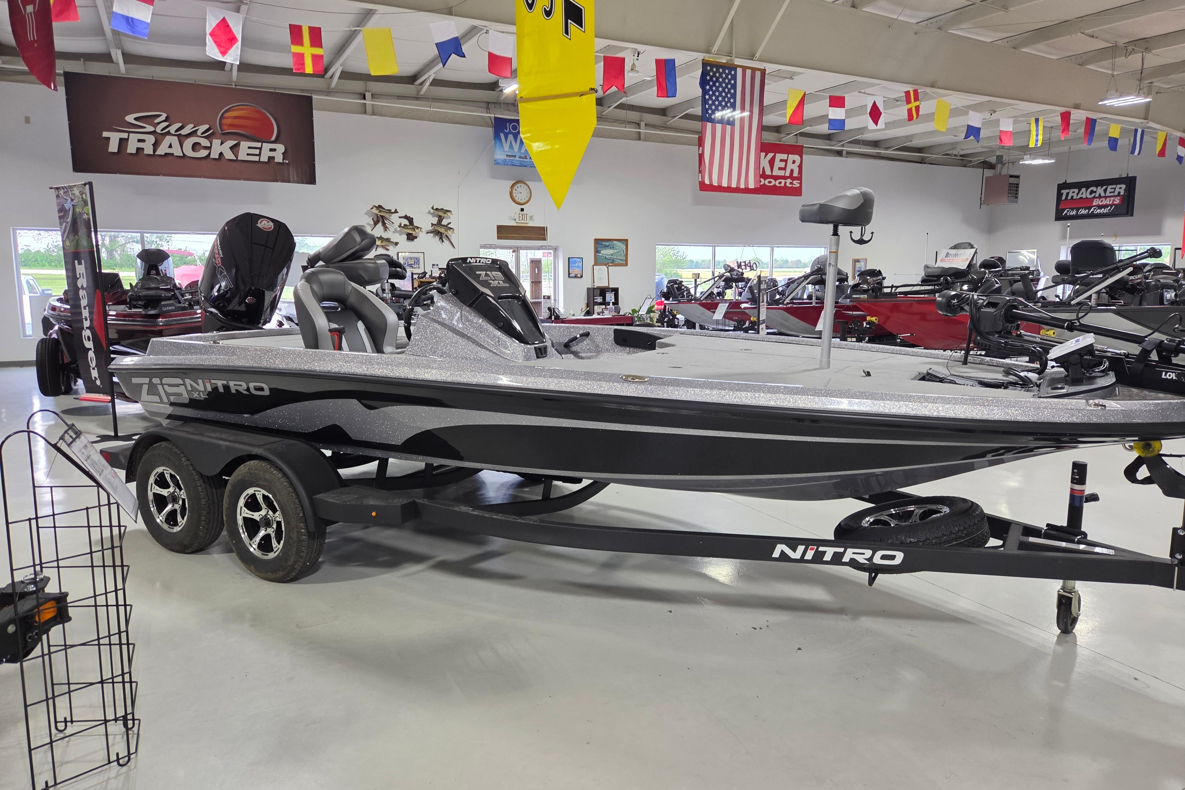 2026 Nitro Z19 XL boat displayed in showroom with flags and promotional banners.