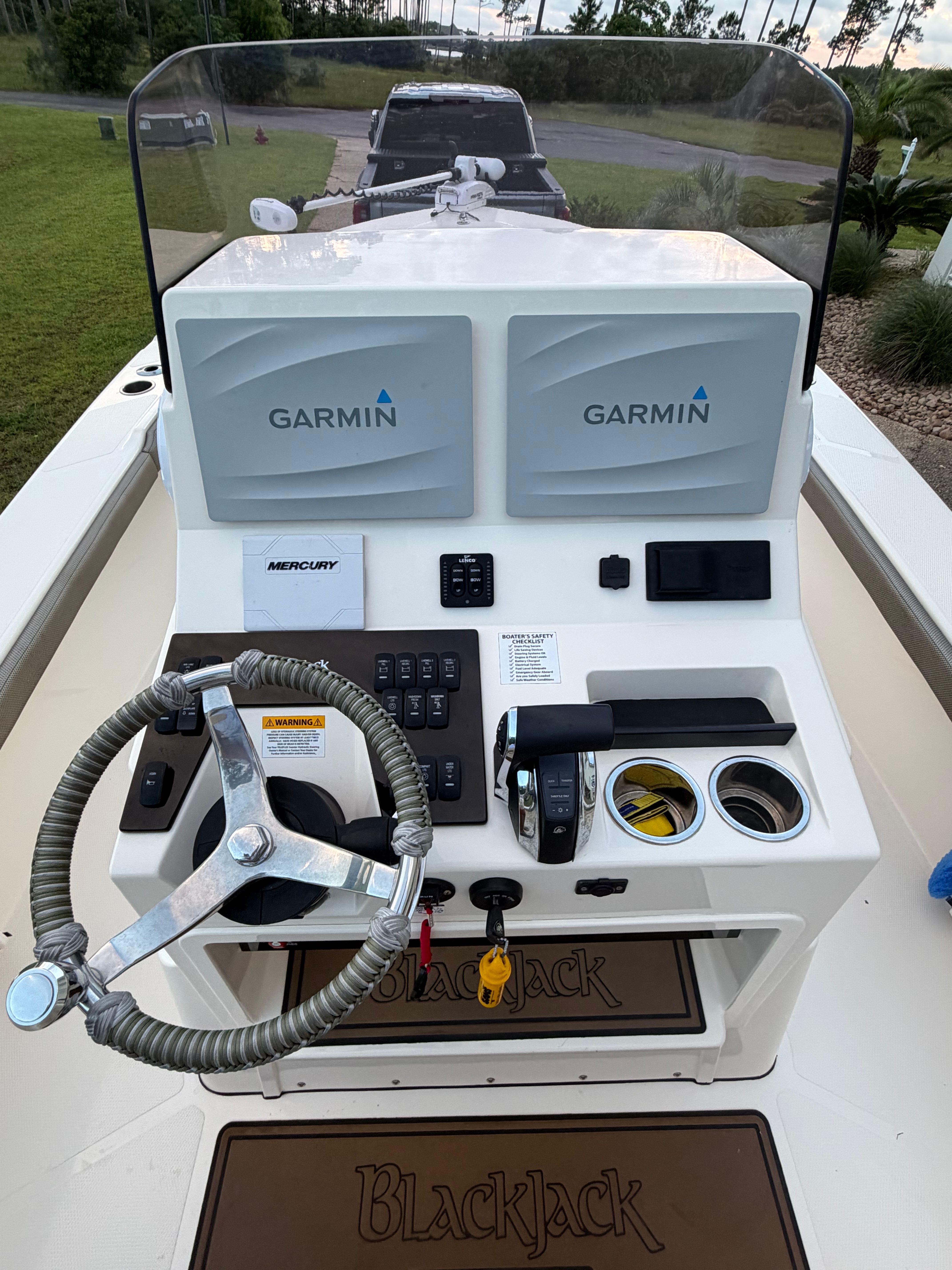 Helm console of a 2022 BlackJack 256 Coastal boat with Garmin displays.