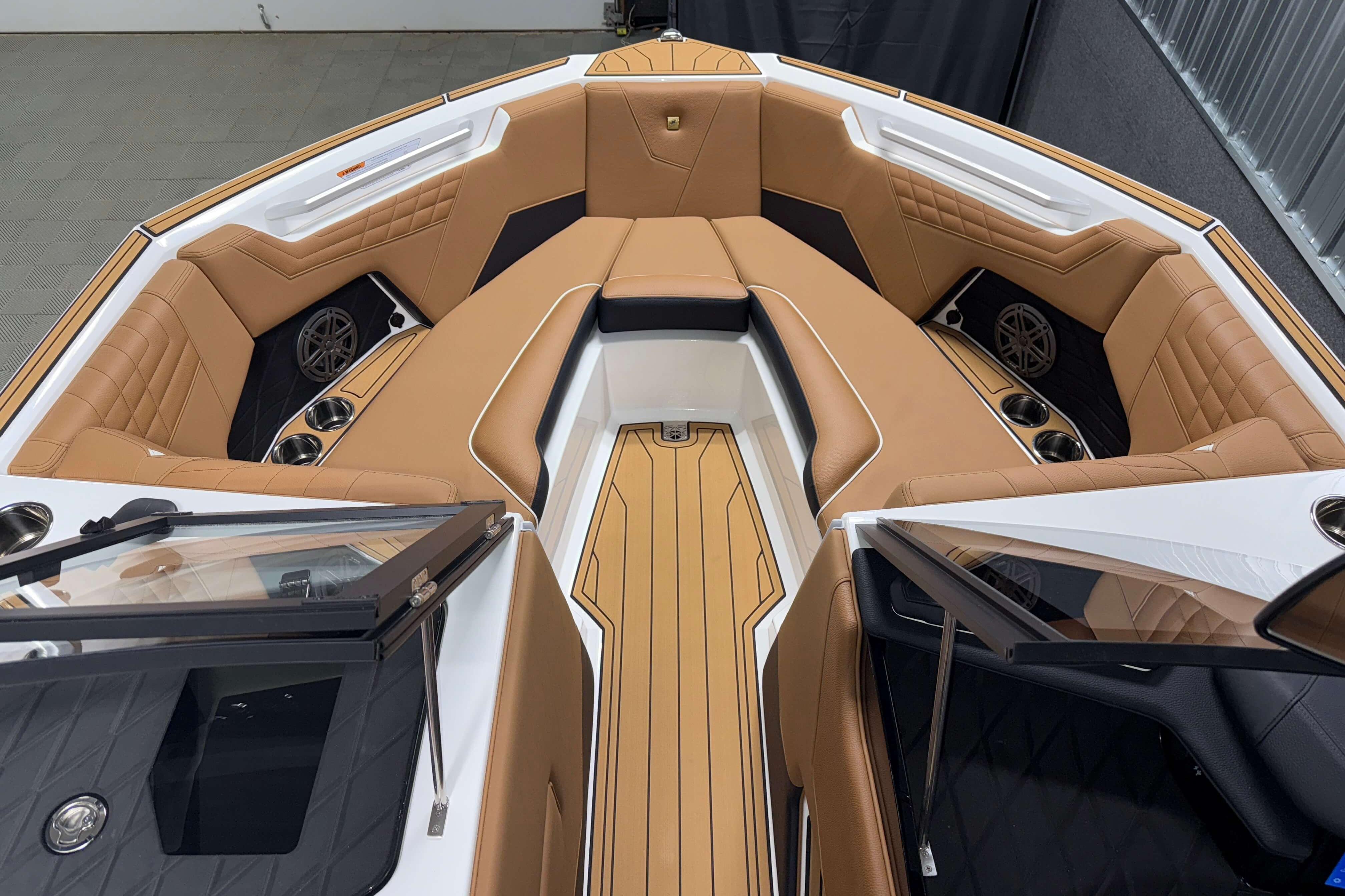 2026 Nautique Super Air Nautique S23 boat interior with tan leather seating and cup holders.